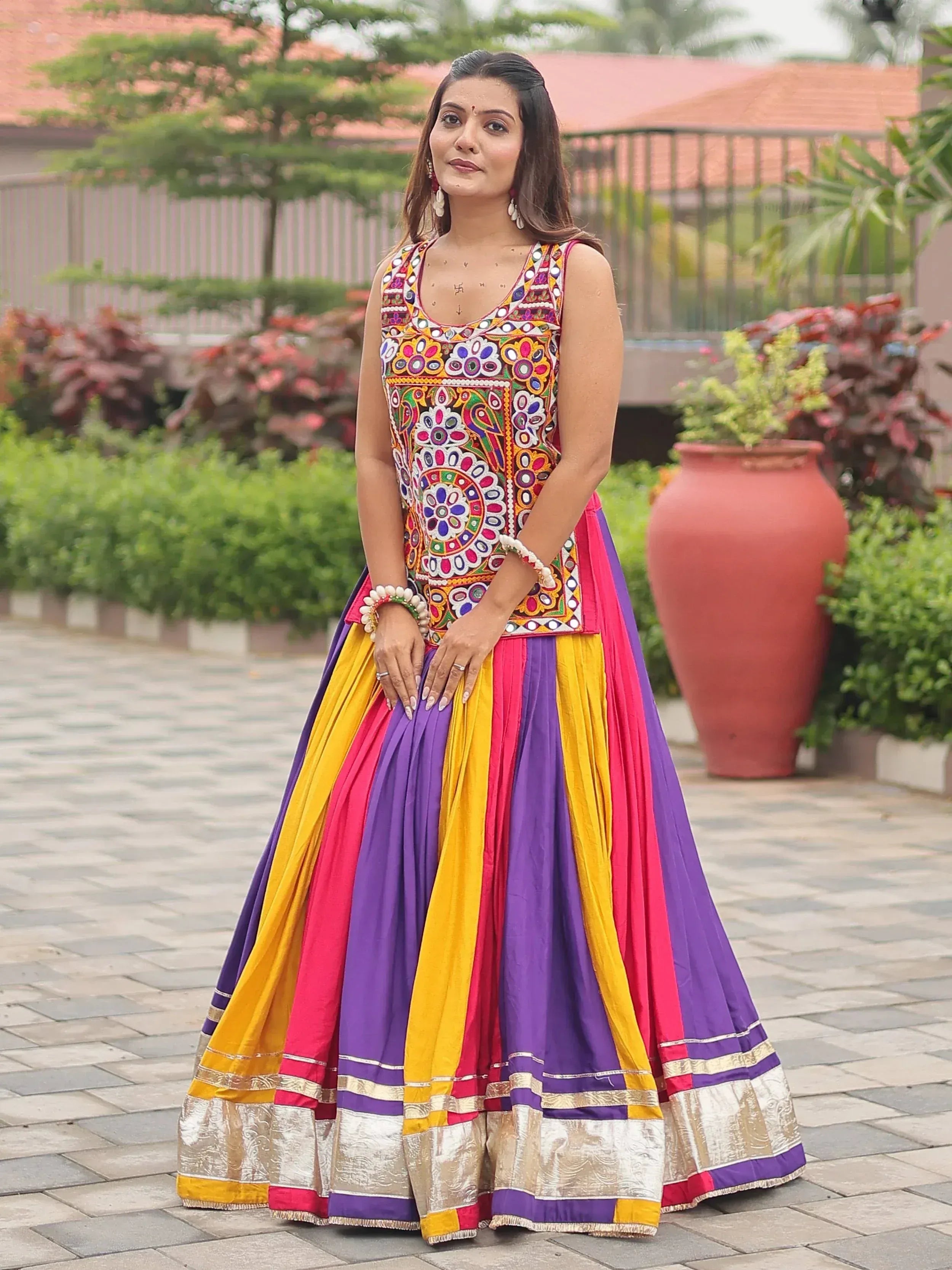 Colorful embroidered lehenga choli with vibrant purple, yellow, and pink pleats, perfect for festive occasions.