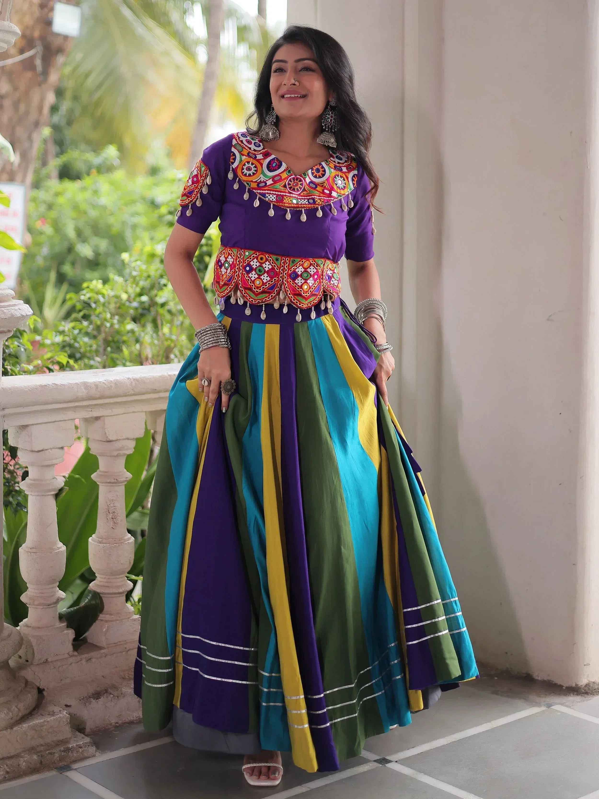 Vibrant purple embroidered top with colorful striped skirt, perfect for Indian ethnic wear occasions.