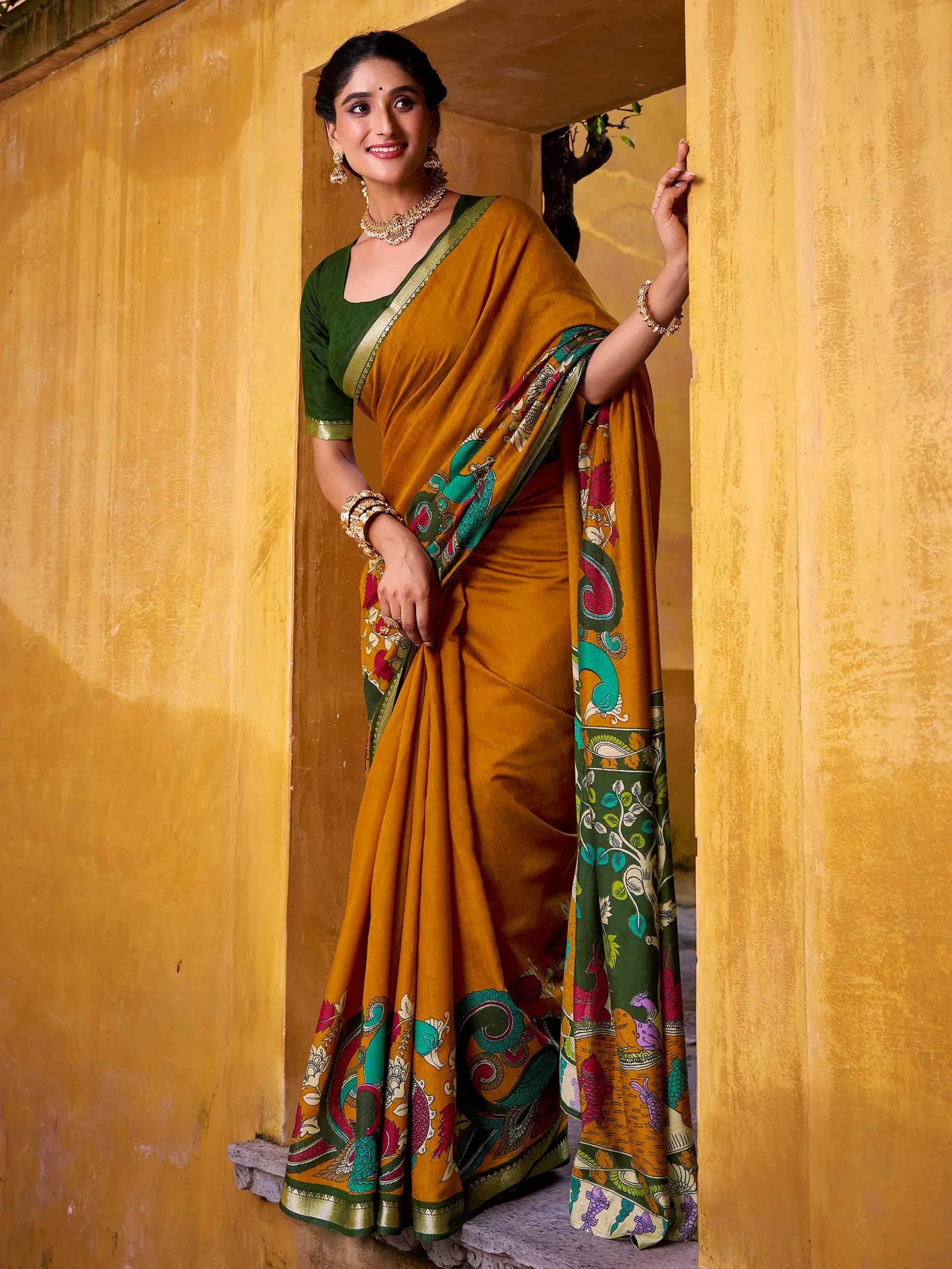 Woman in mustard yellow printed saree with green blouse, traditional Indian ethnic wear