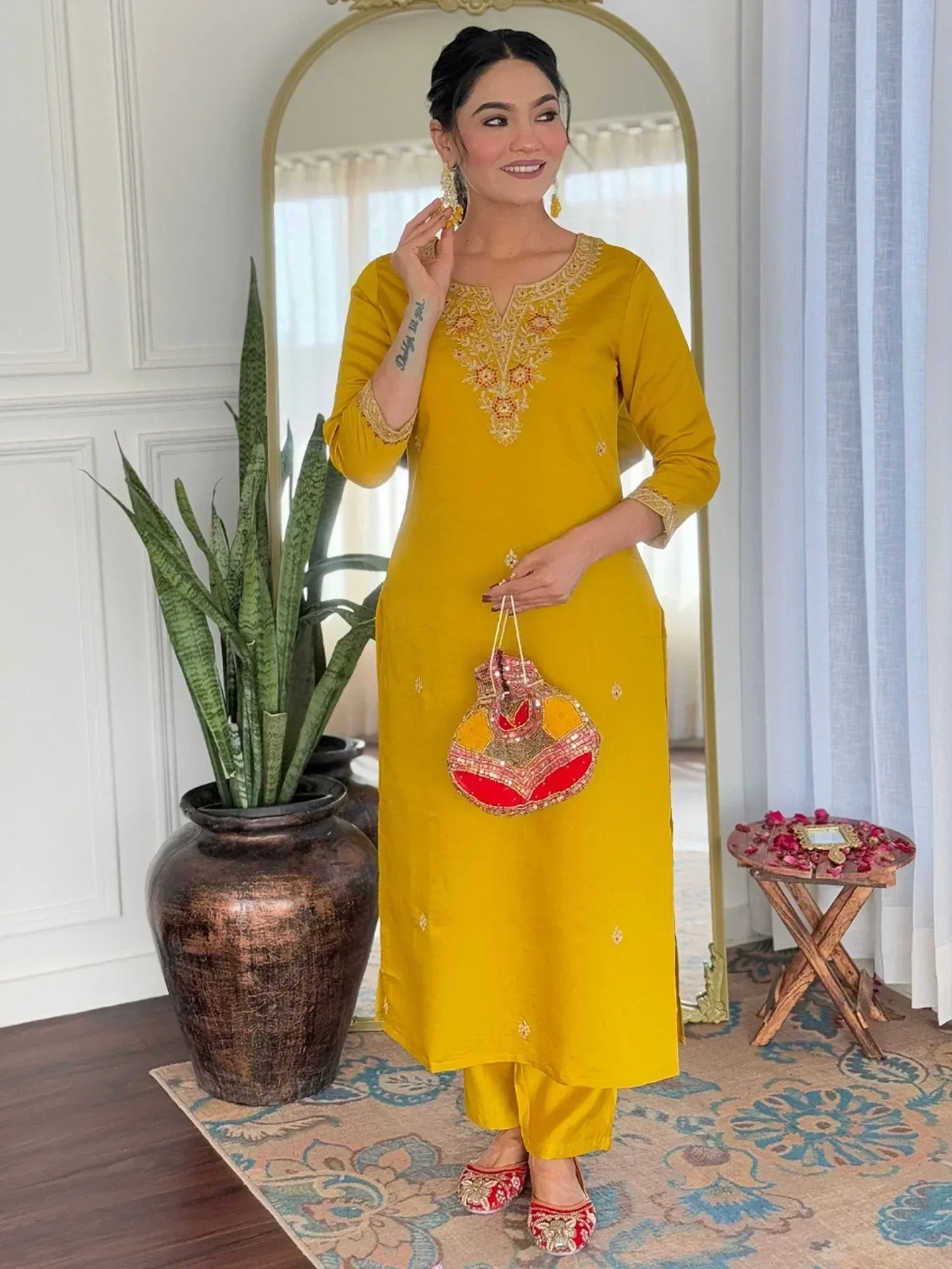 Yellow embroidered kurta with matching pants, traditional Indian ethnic wear, paired with embellished clutch and juttis