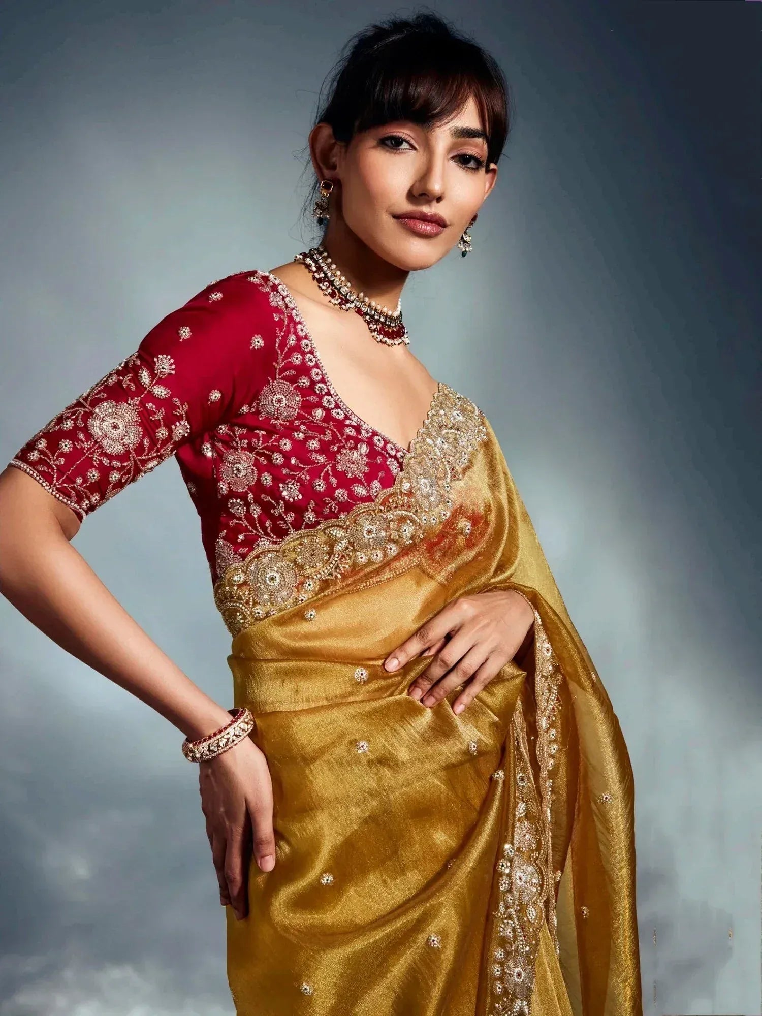 Elegant gold saree with red embroidered blouse, perfect for Indian ethnic occasions and festive wear.