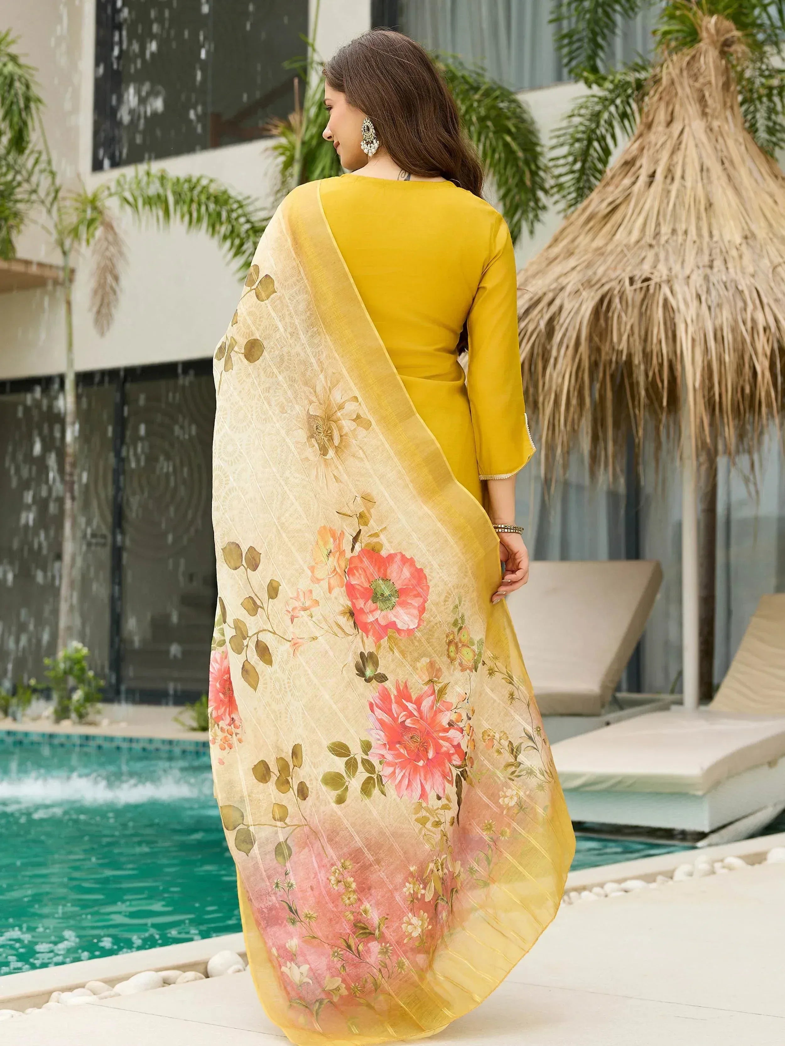 Yellow ethnic saree with floral print, worn by woman near poolside, perfect for Indian occasions