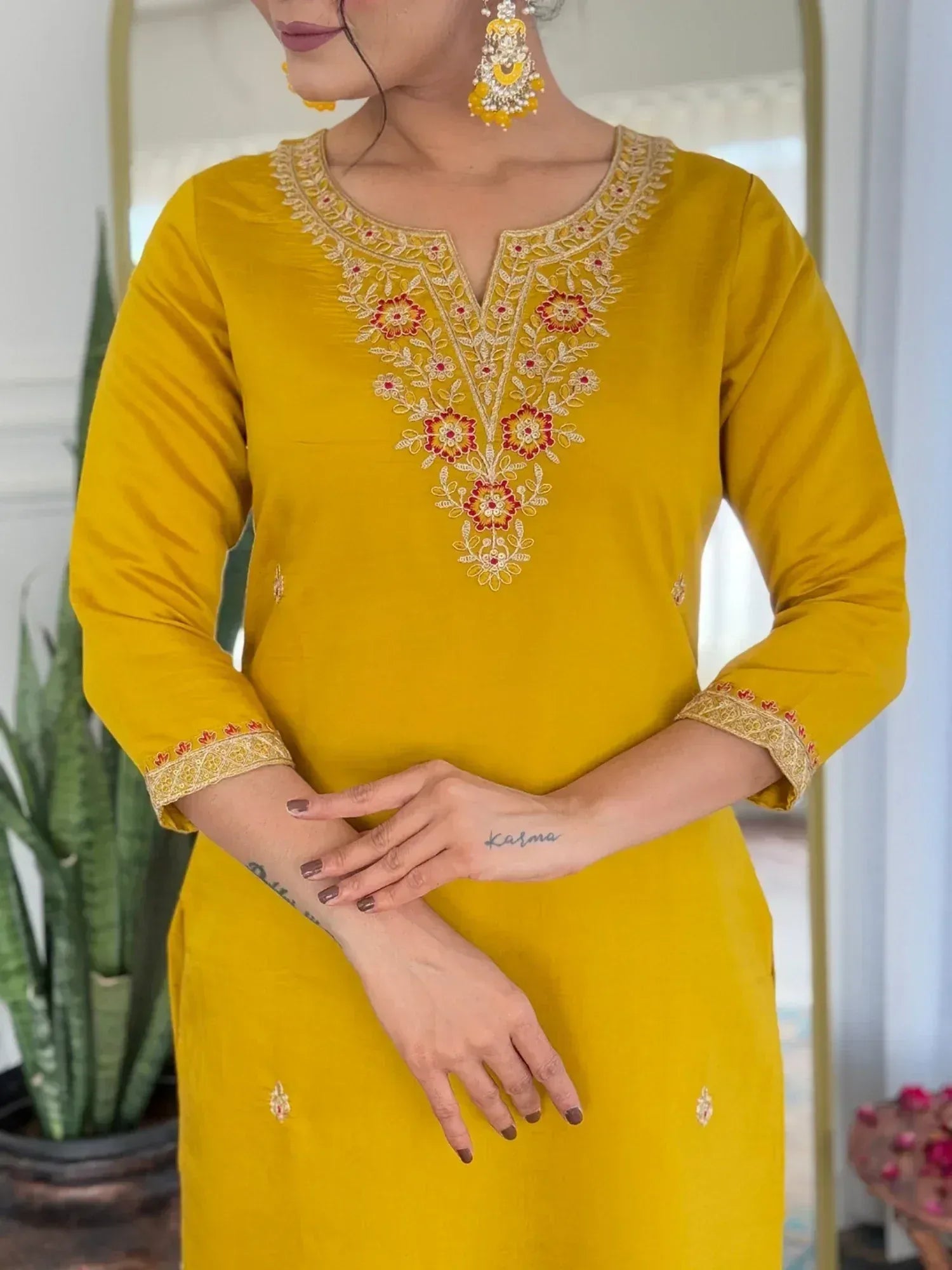 Yellow embroidered ethnic kurti with floral neckline and sleeve detailing, paired with statement earrings