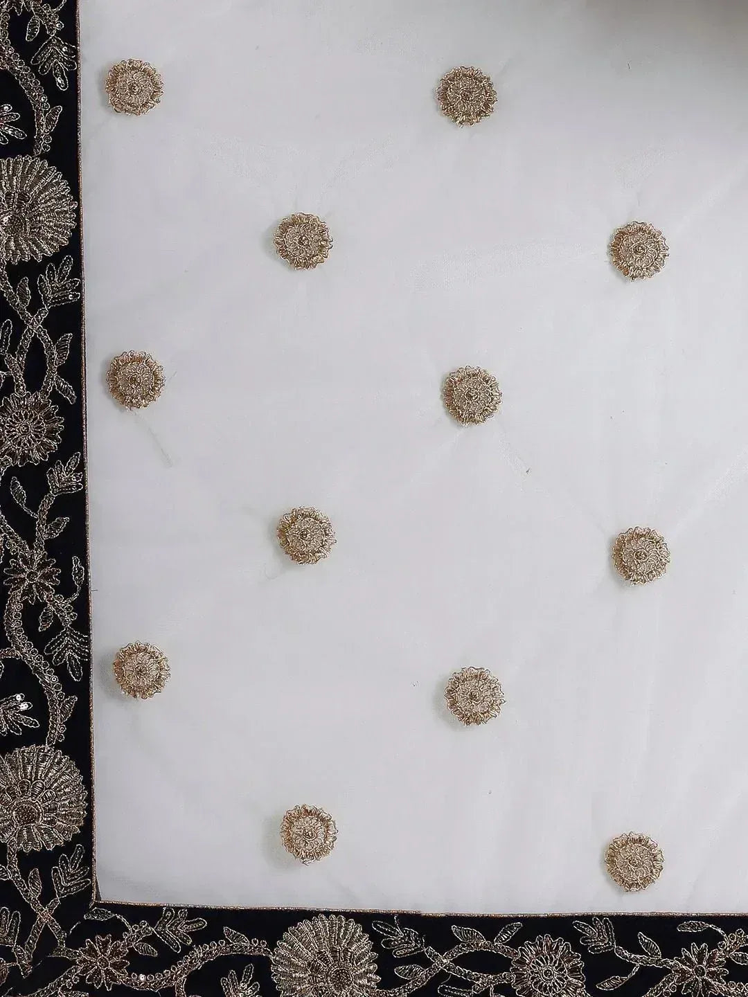 White ethnic fabric with gold floral embroidery and black border, ideal for designer lehenga or saree