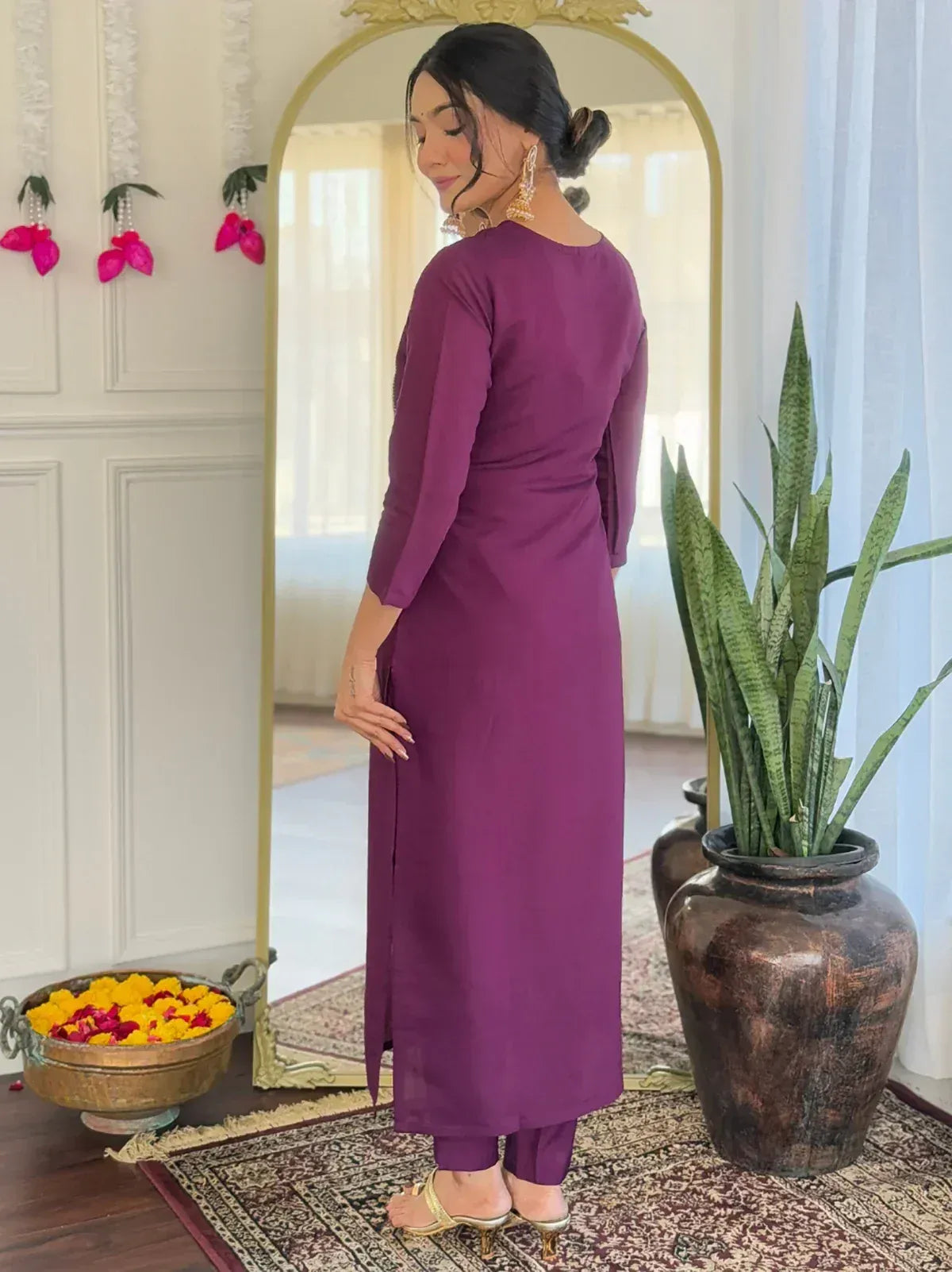 Purple ethnic gown with side slit, paired with matching pants and gold heels, styled for Indian wear.