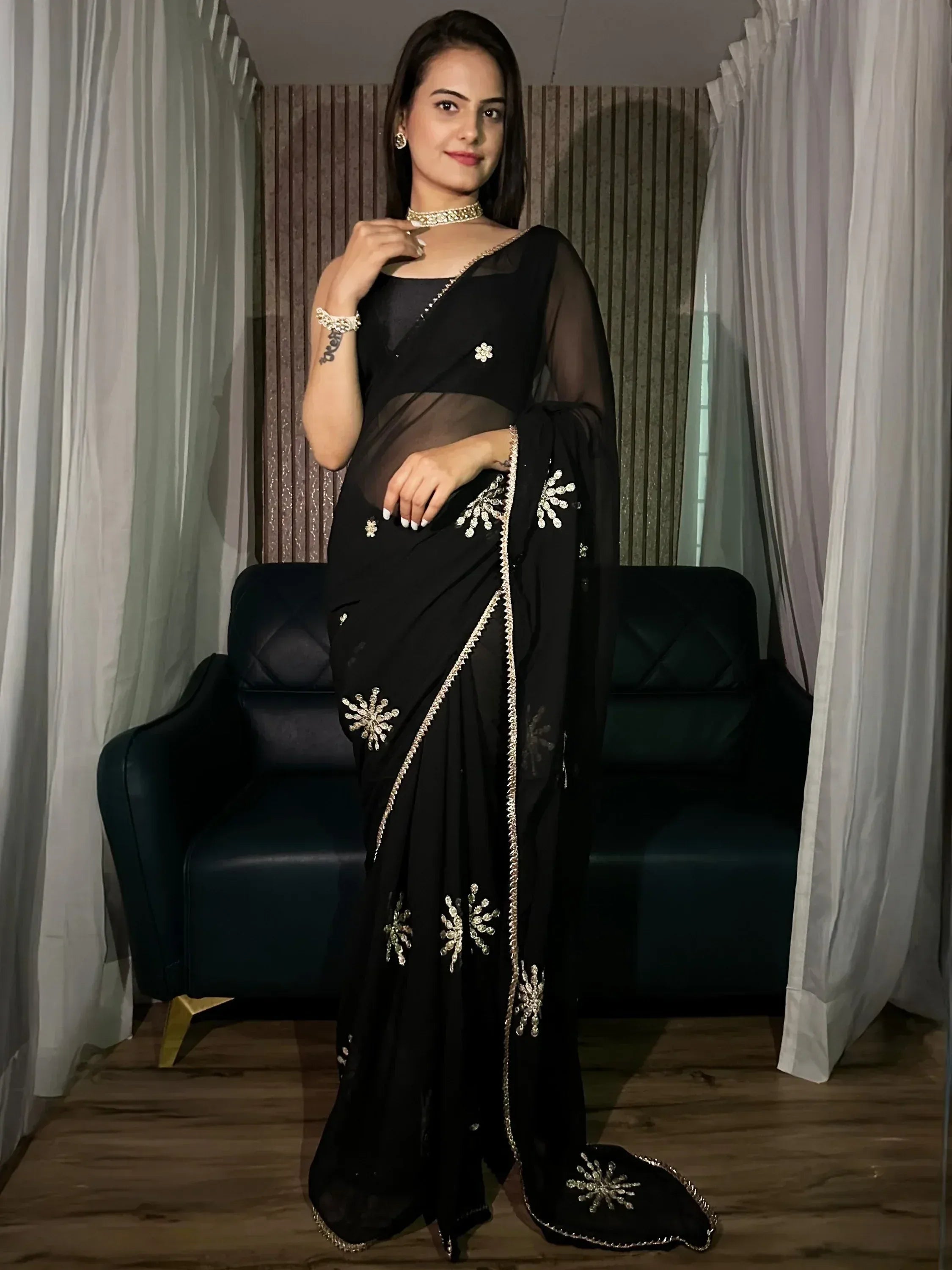 Black sheer saree with gold floral embroidery, perfect for Indian ethnic wear events
