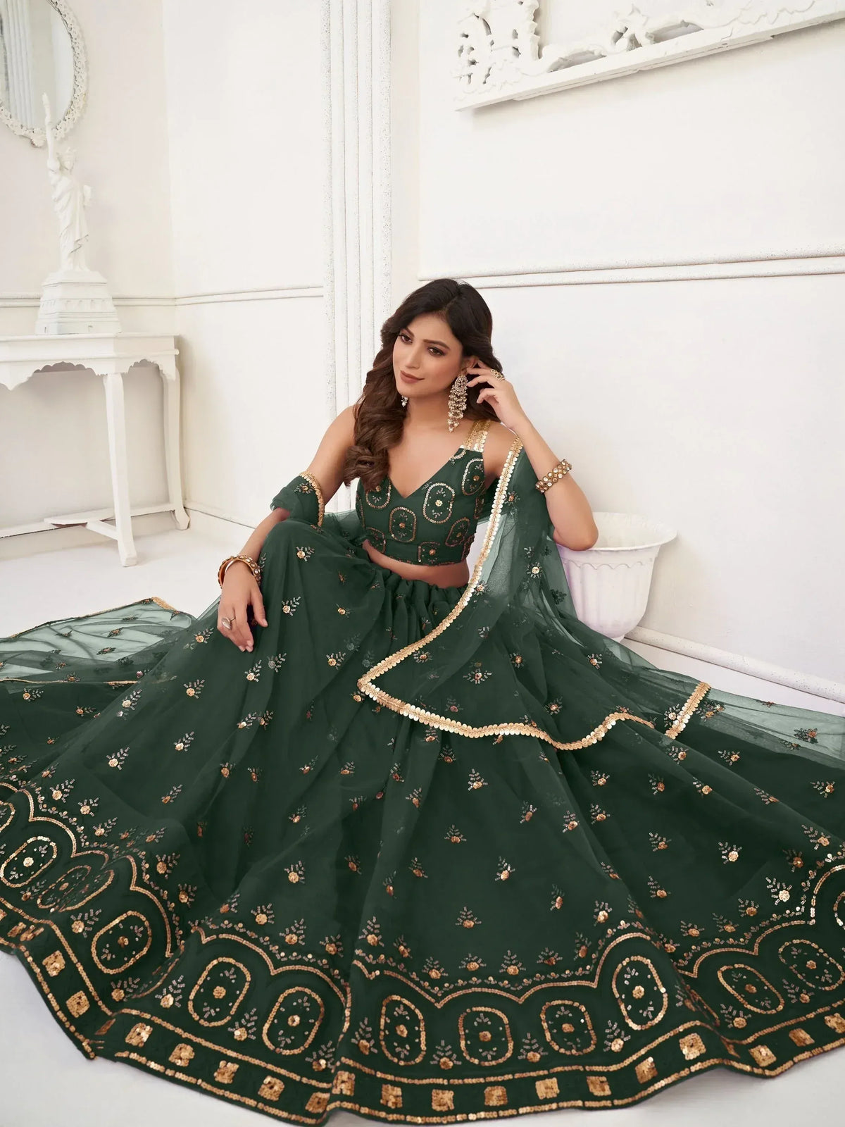Emerald green designer lehenga choli with gold embroidery, perfect for Indian weddings and festive occasions.
