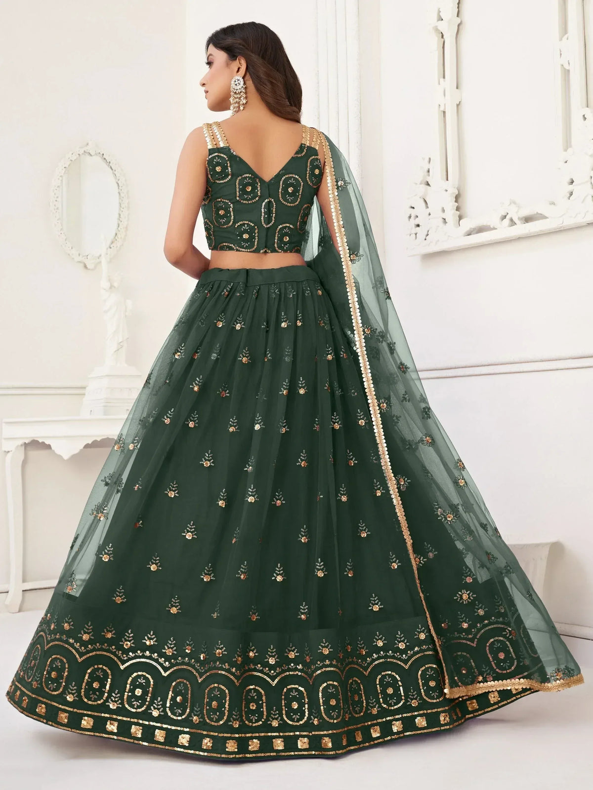 Emerald green designer lehenga choli with gold embroidery and sheer dupatta, perfect for Indian weddings and festive occasions.
