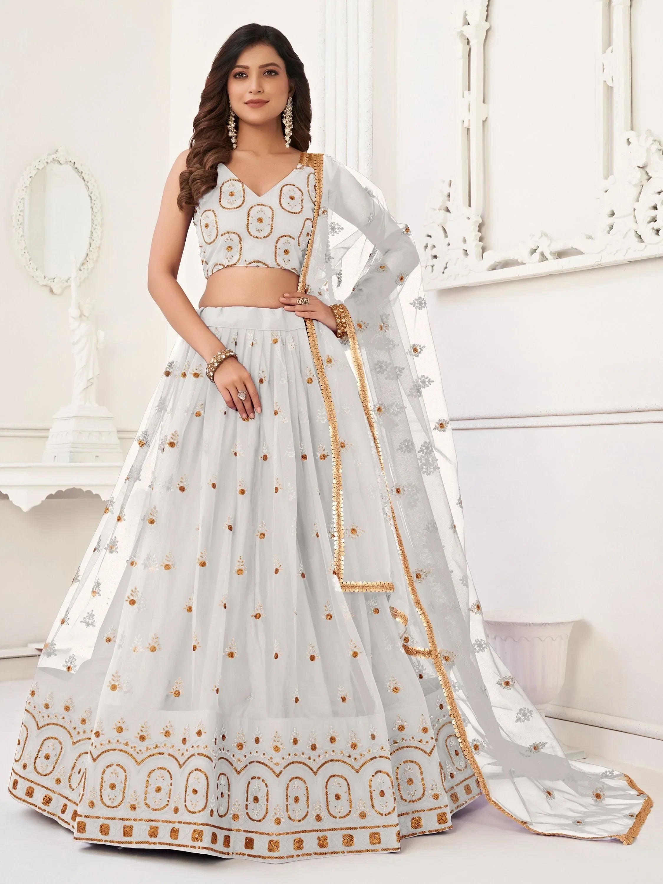 Elegant white lehenga choli with gold embroidery, perfect for Indian weddings and festive occasions.