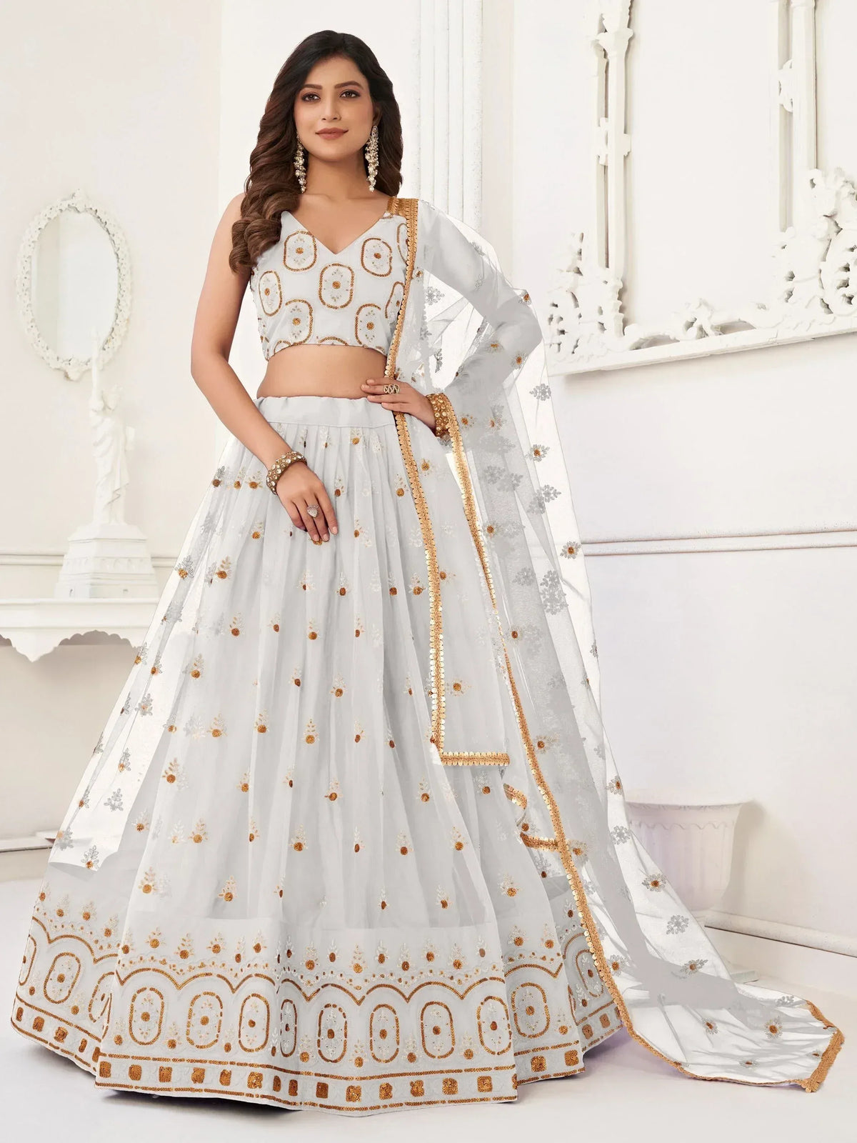 Elegant white lehenga choli with gold embroidery, perfect for Indian weddings and festive occasions.