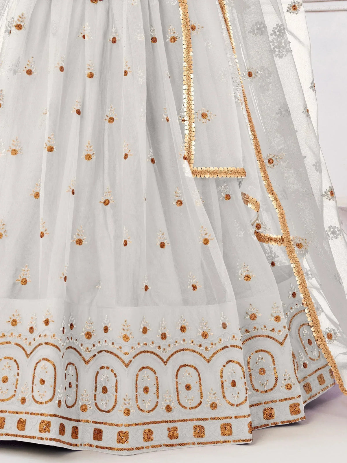 White ethnic lehenga with gold floral embroidery and sequin detailing, perfect for Indian weddings and festivals