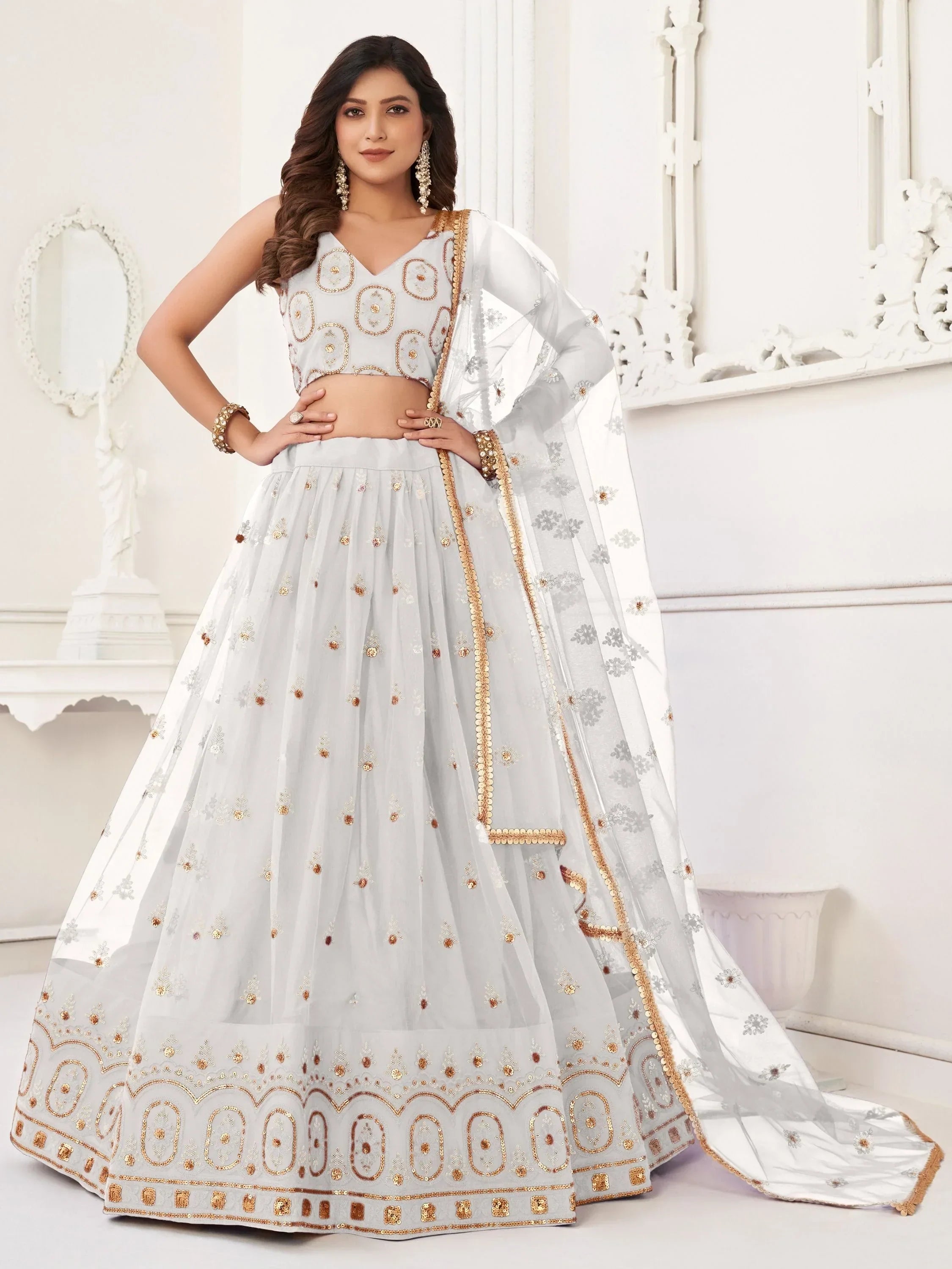 Elegant white lehenga choli with gold embroidery, perfect for Indian weddings and festive occasions.