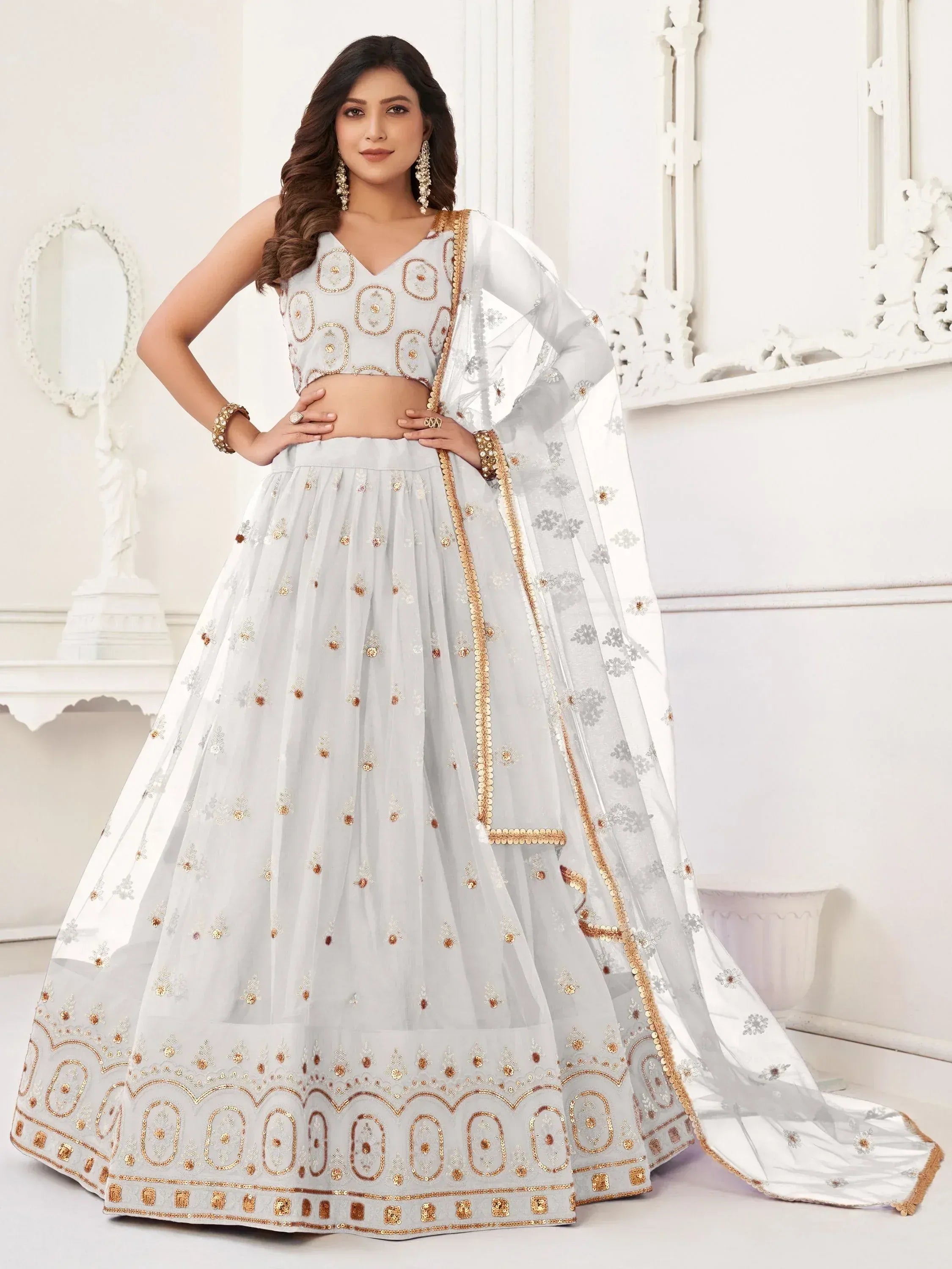 Elegant white lehenga choli with gold embroidery, perfect for Indian weddings and festive occasions.