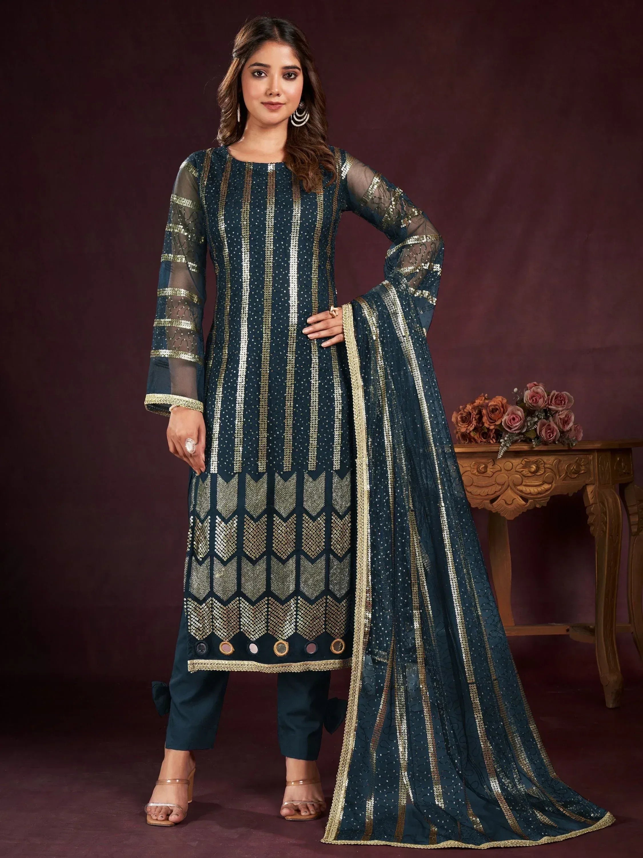Dark green ethnic salwar kameez with gold sequin work and sheer sleeves, perfect for festive occasions.