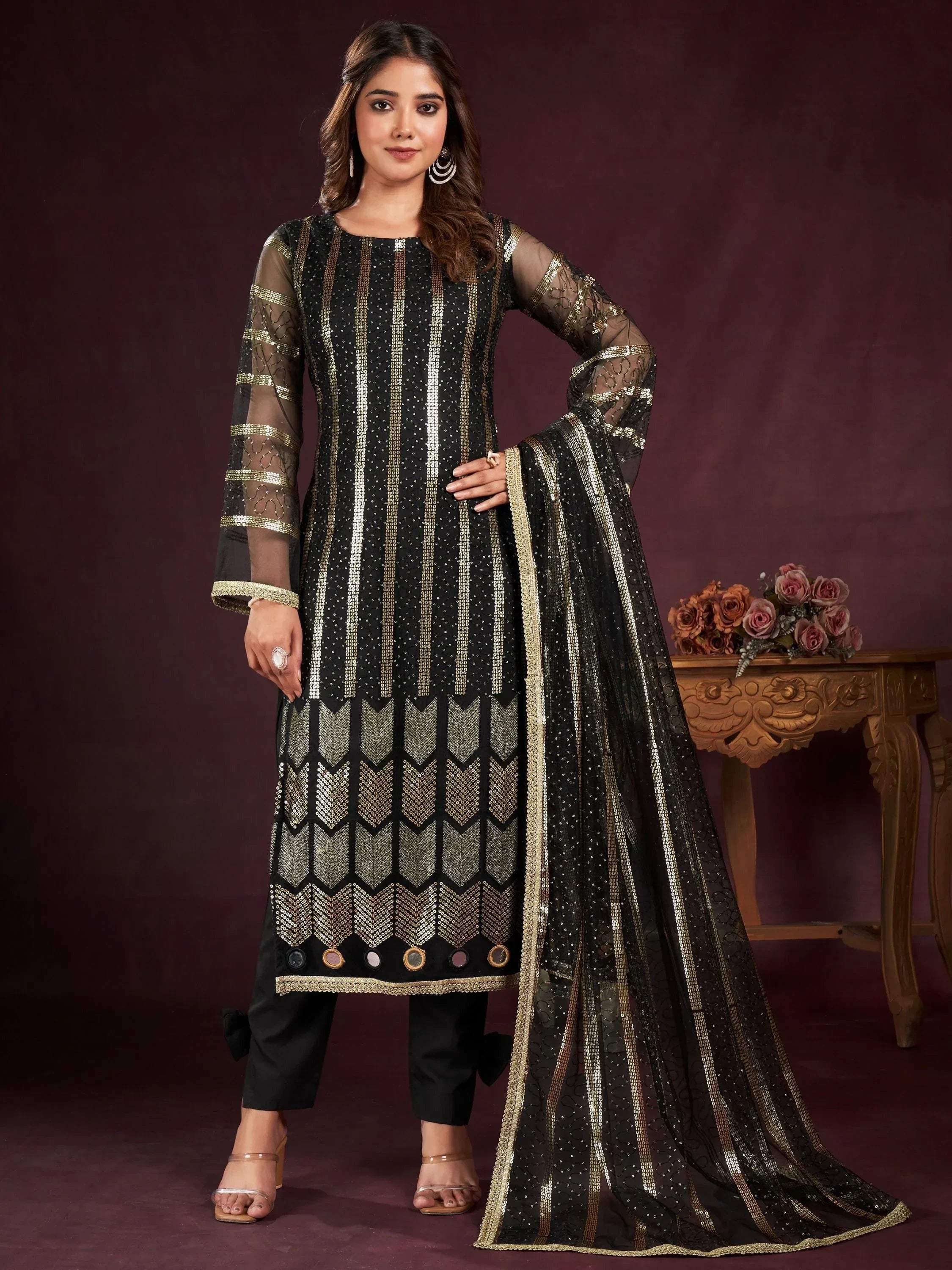 Woman wearing black and gold embroidered salwar kameez with dupatta, traditional Indian outfit