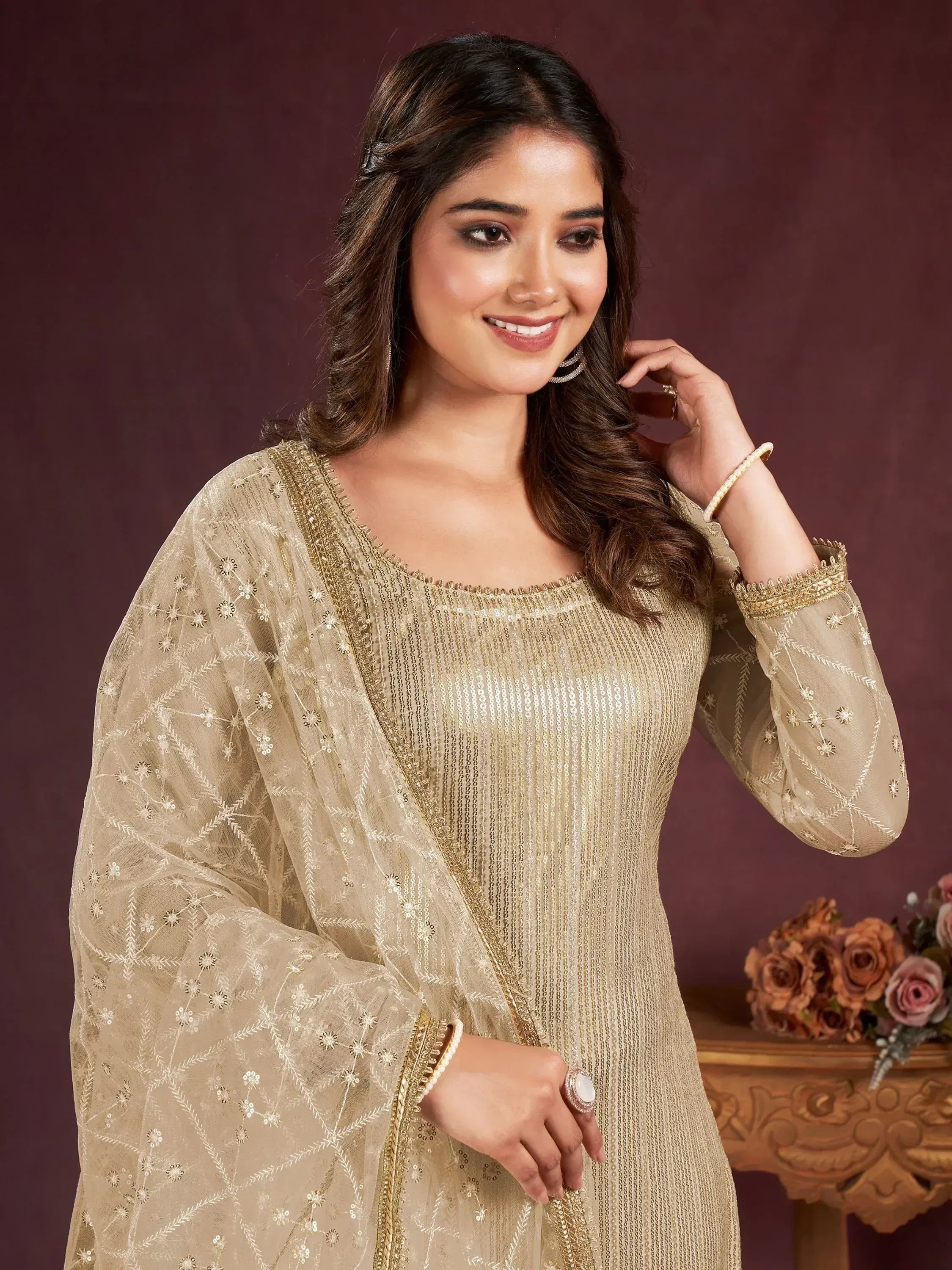 Elegant gold embroidered ethnic gown with sheer dupatta, perfect for festive occasions.