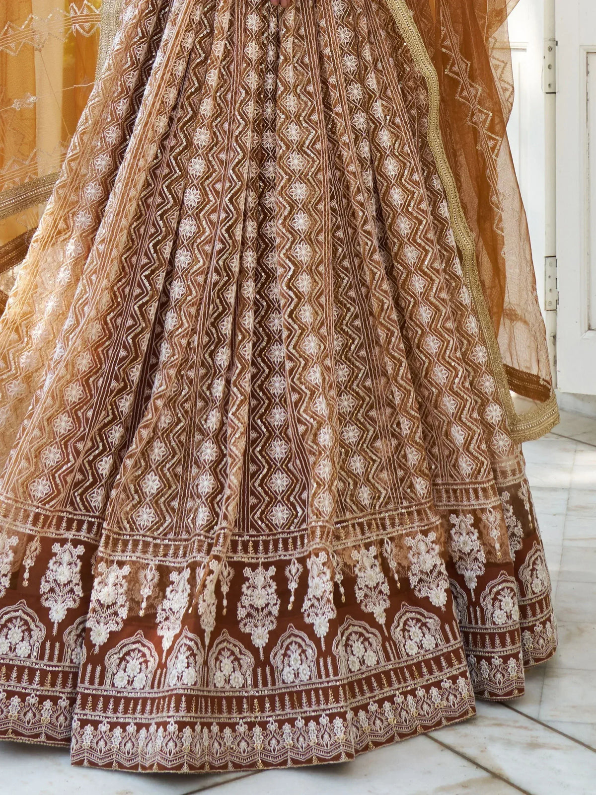 Brown embroidered lehenga choli with floral and geometric patterns, perfect for Indian ethnic wear