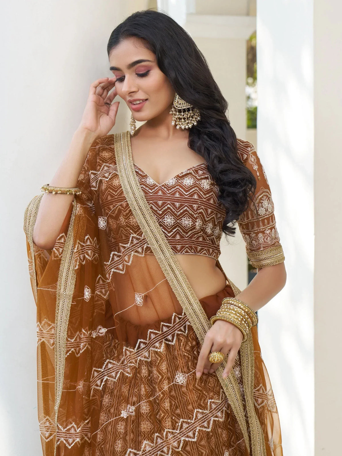 Elegant brown embroidered lehenga choli with gold detailing, perfect for Indian ethnic wear occasions.