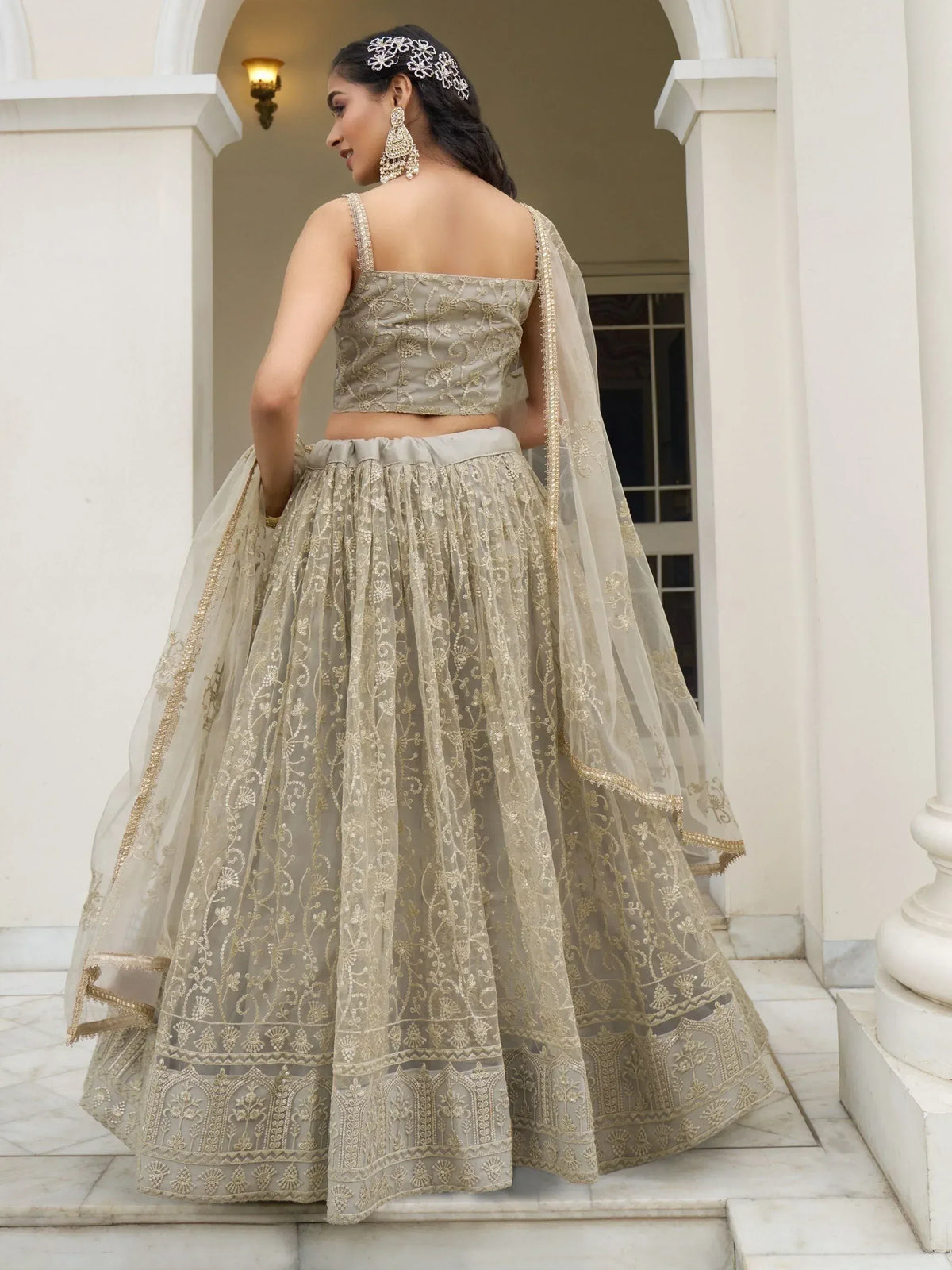 Elegant beige embroidered lehenga choli with gold detailing, perfect for Indian weddings and festive occasions.