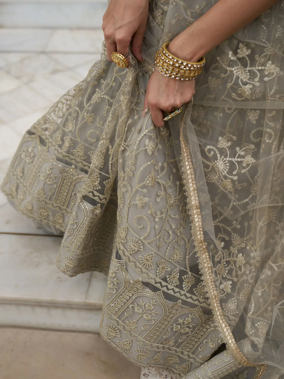 Grey lehenga with gold floral embroidery and matching jewelry, ideal for Indian ethnic wear occasions.