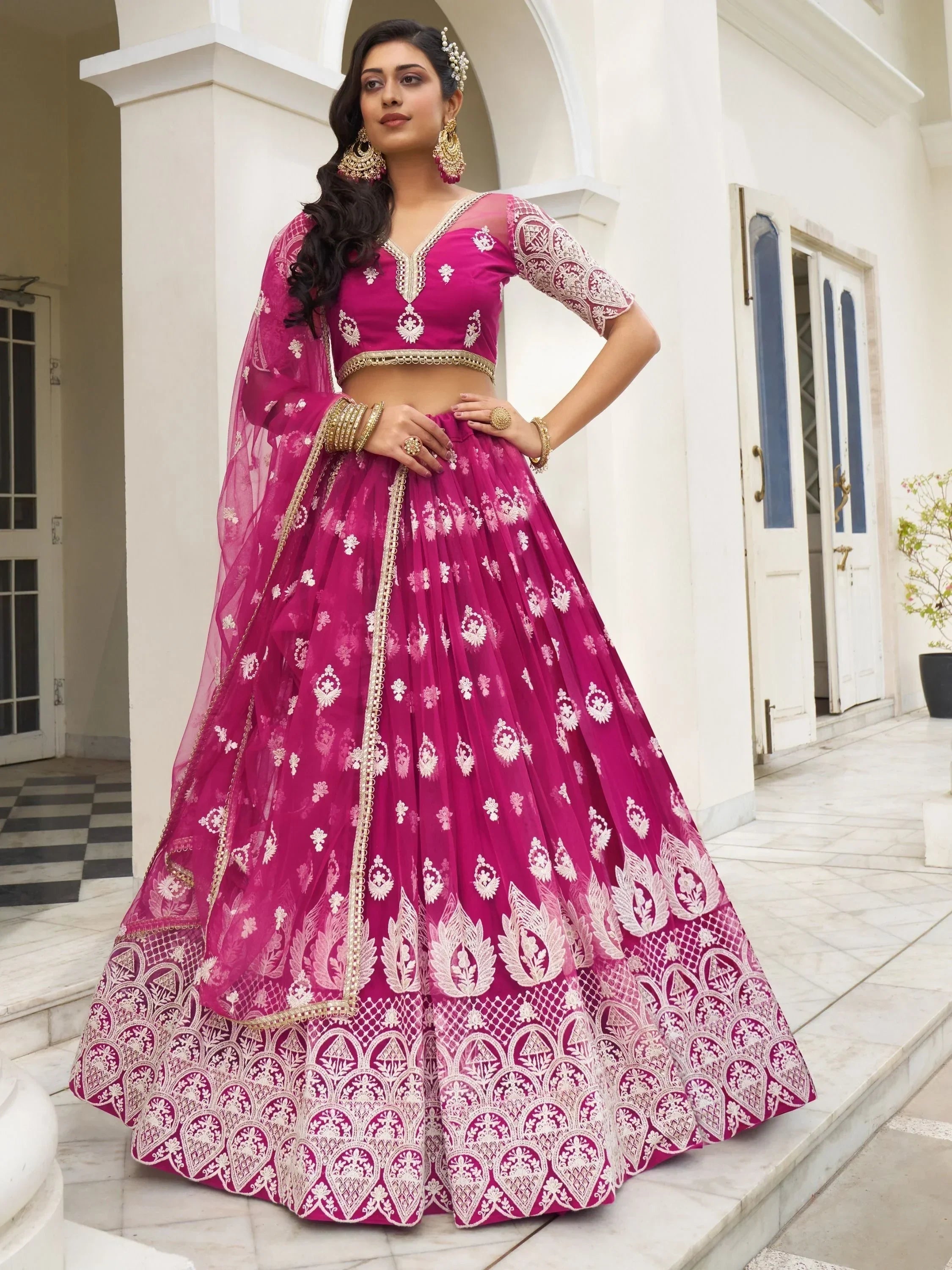 Fuchsia designer lehenga choli with white embroidery, perfect for Indian weddings and festive occasions.