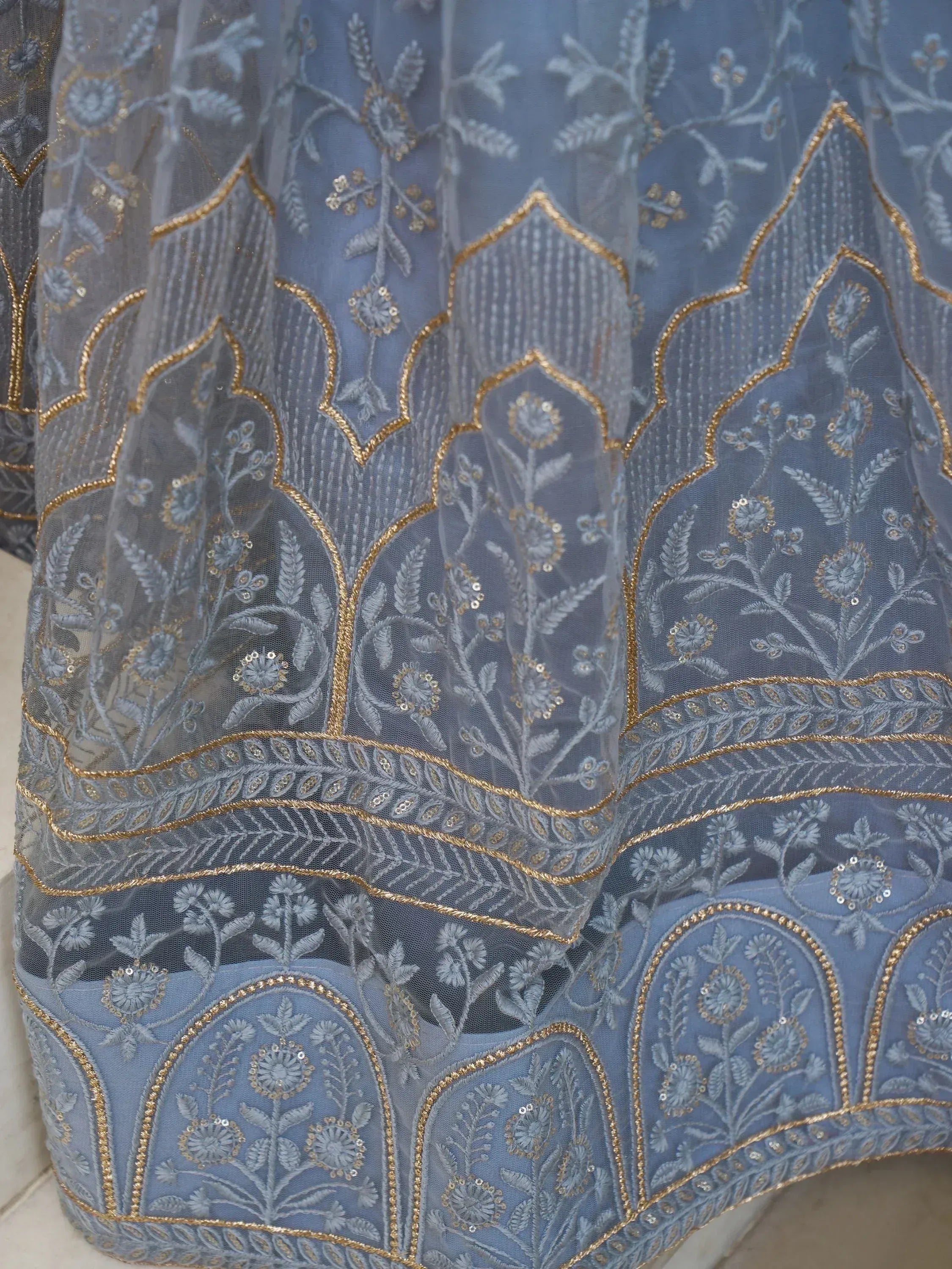 Blue embroidered lehenga with gold thread floral patterns and sheer net overlay