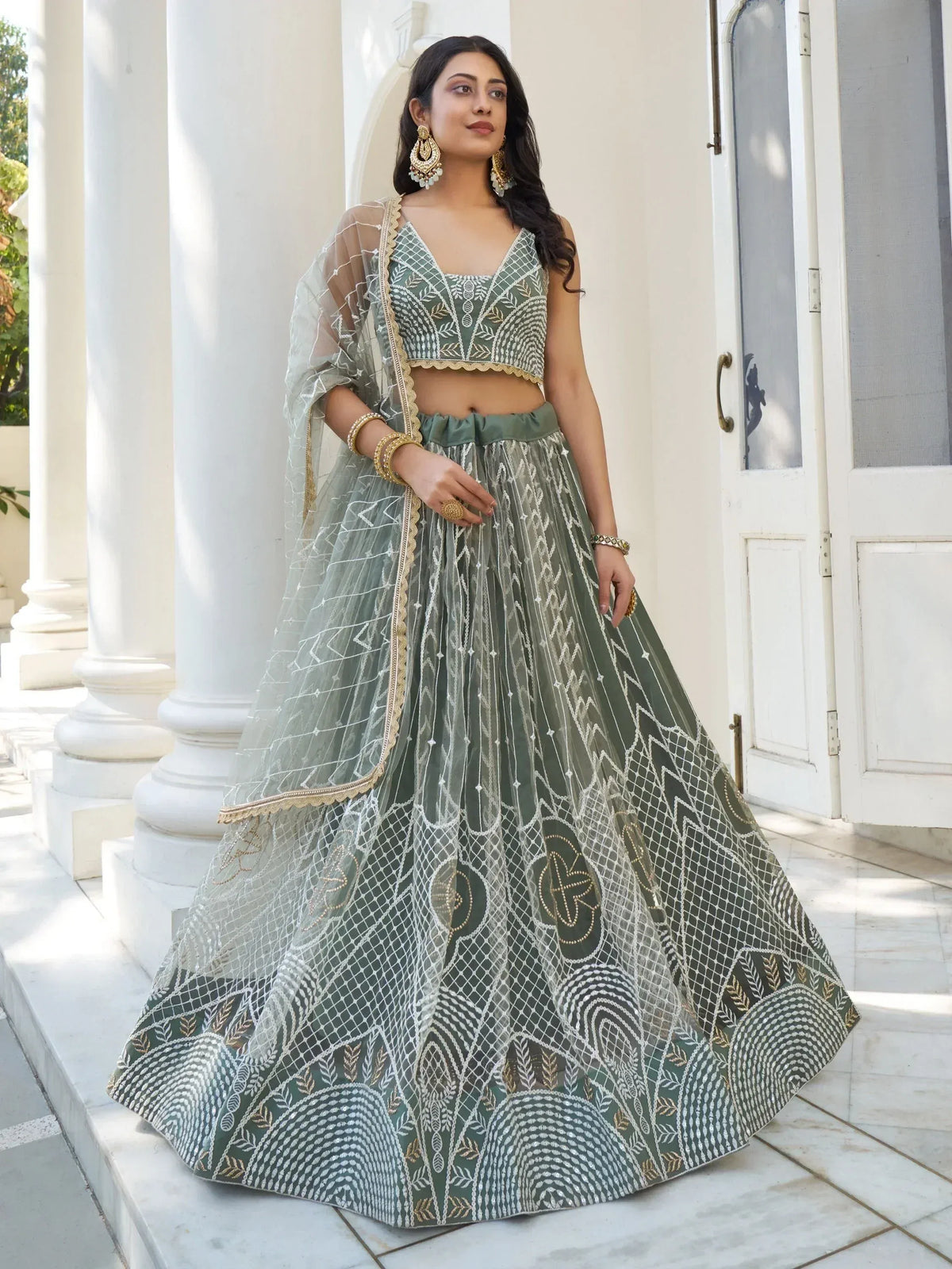 Elegant olive green lehenga choli with intricate white and gold embroidery, perfect for Indian ethnic wear occasions.