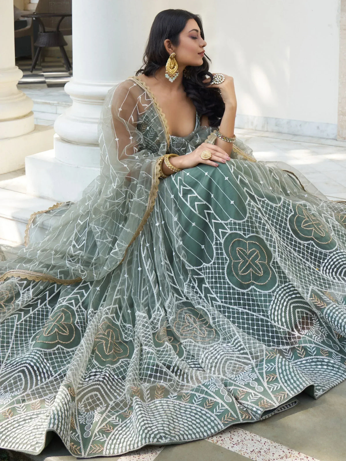 Elegant green designer lehenga choli with intricate white and gold embroidery, perfect for Indian ethnic wear.