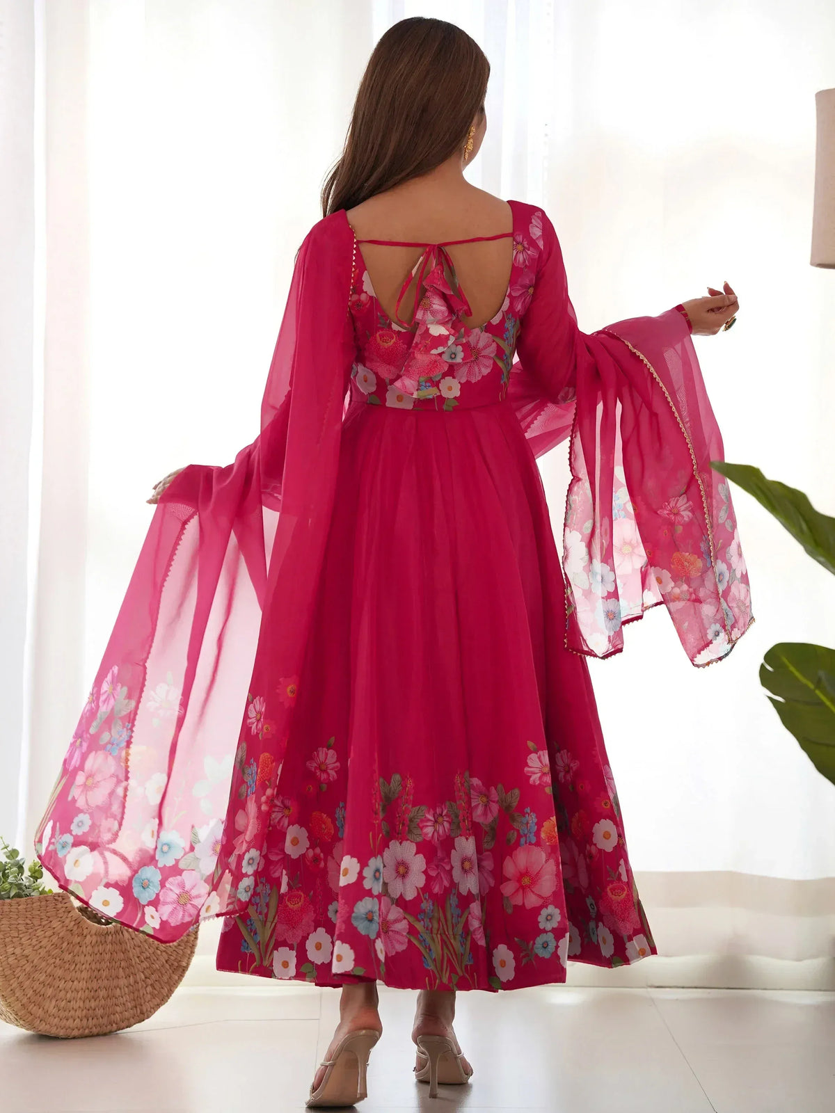 Pink floral ethnic gown with sheer bell sleeves and back tie detail, perfect for Indian occasions.