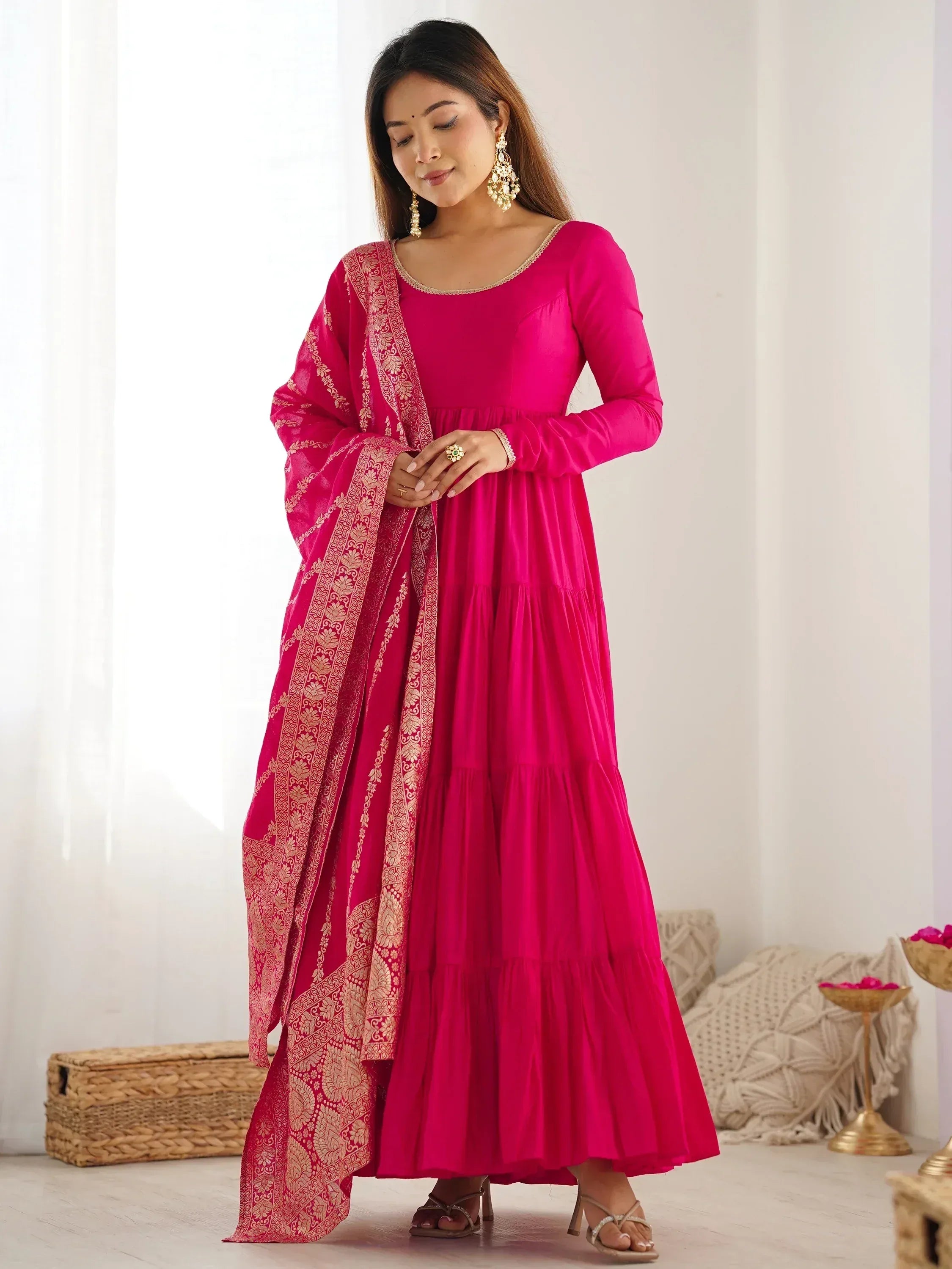 Fuchsia tiered ethnic gown with gold embroidered dupatta, perfect for Indian occasions and festive wear.