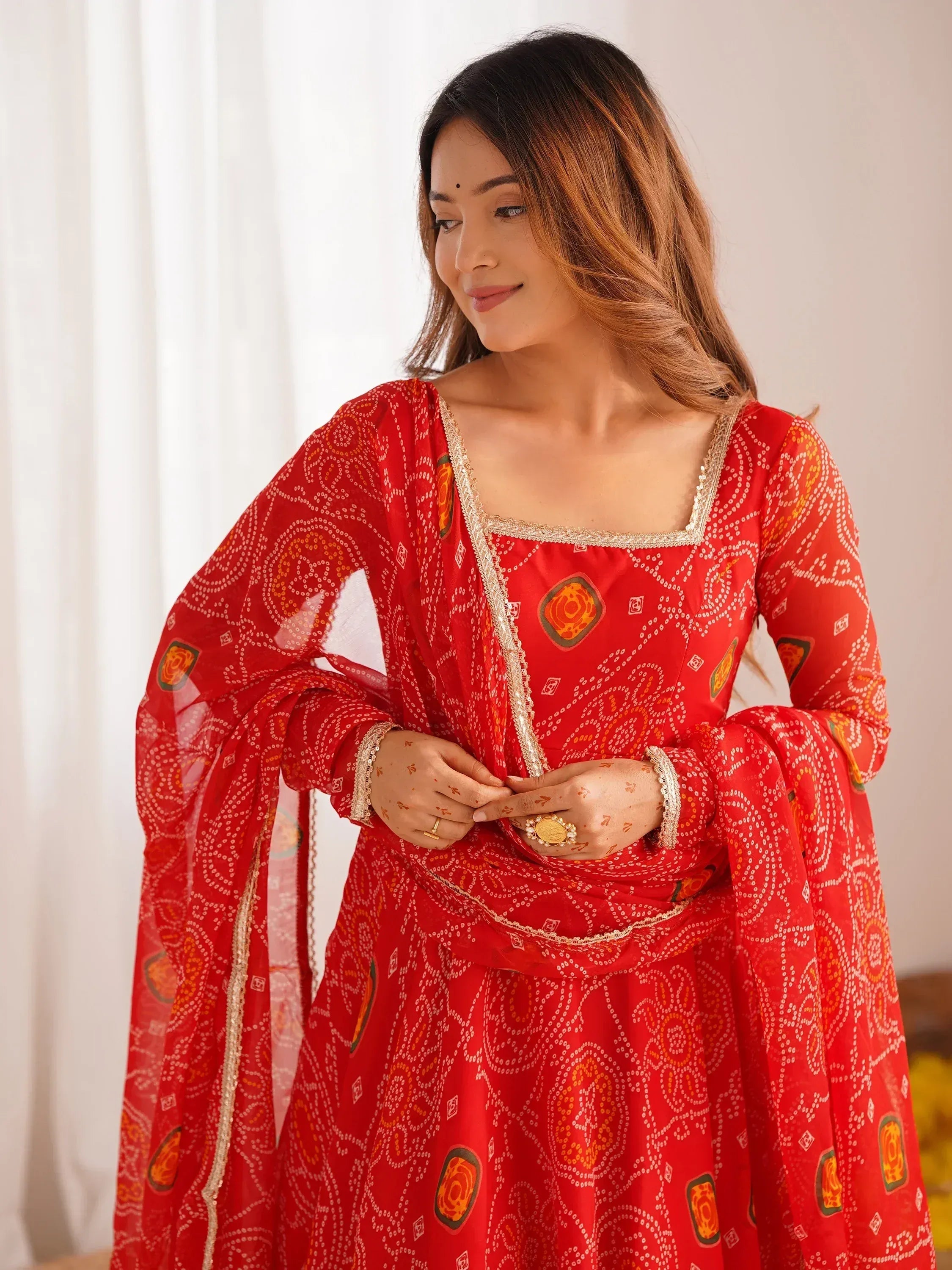 Red printed ethnic gown with gold trim, perfect for Indian occasions and festive wear.