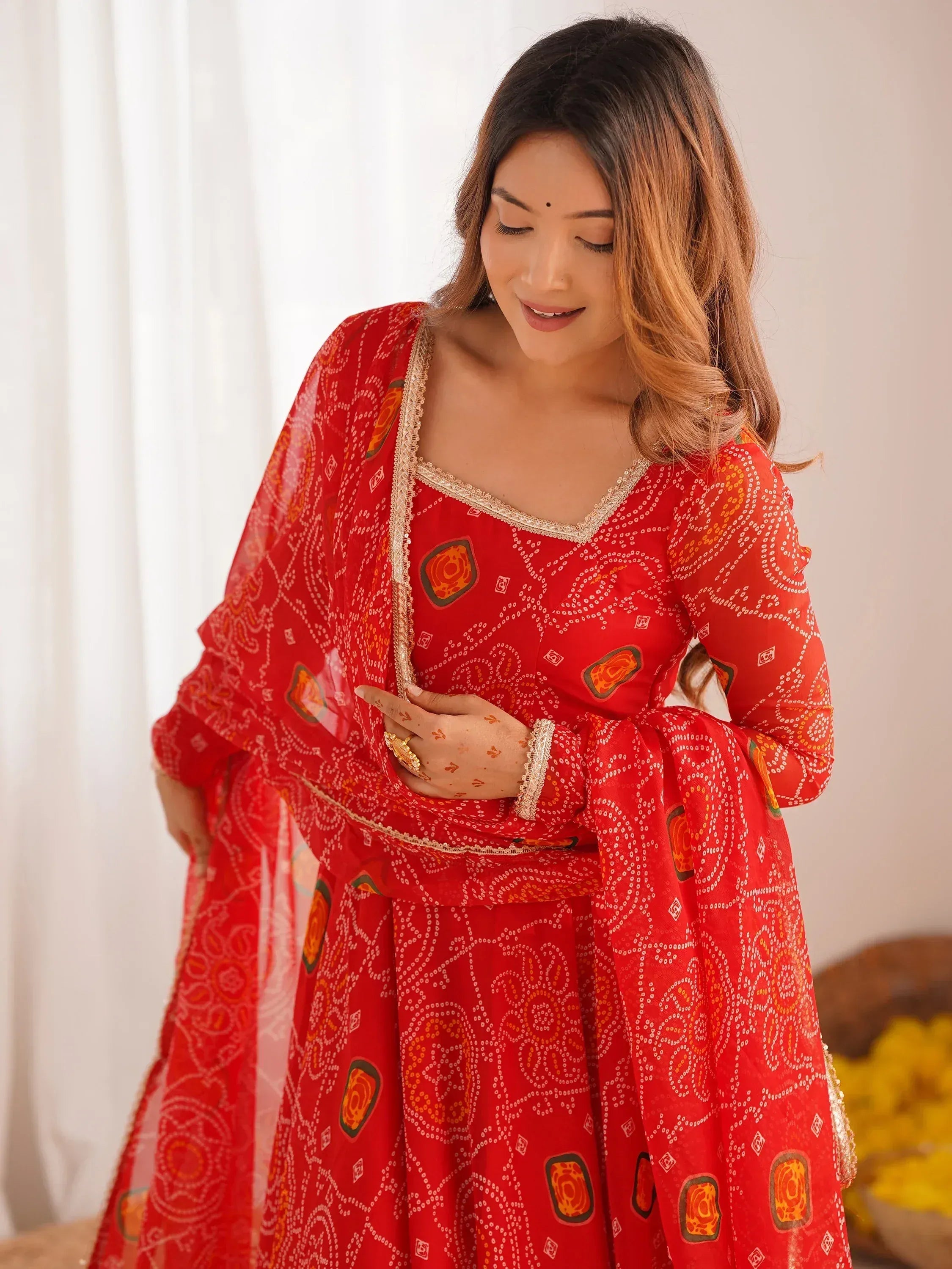 Red printed ethnic anarkali suit with gold trim, perfect for Indian occasions and festive wear.