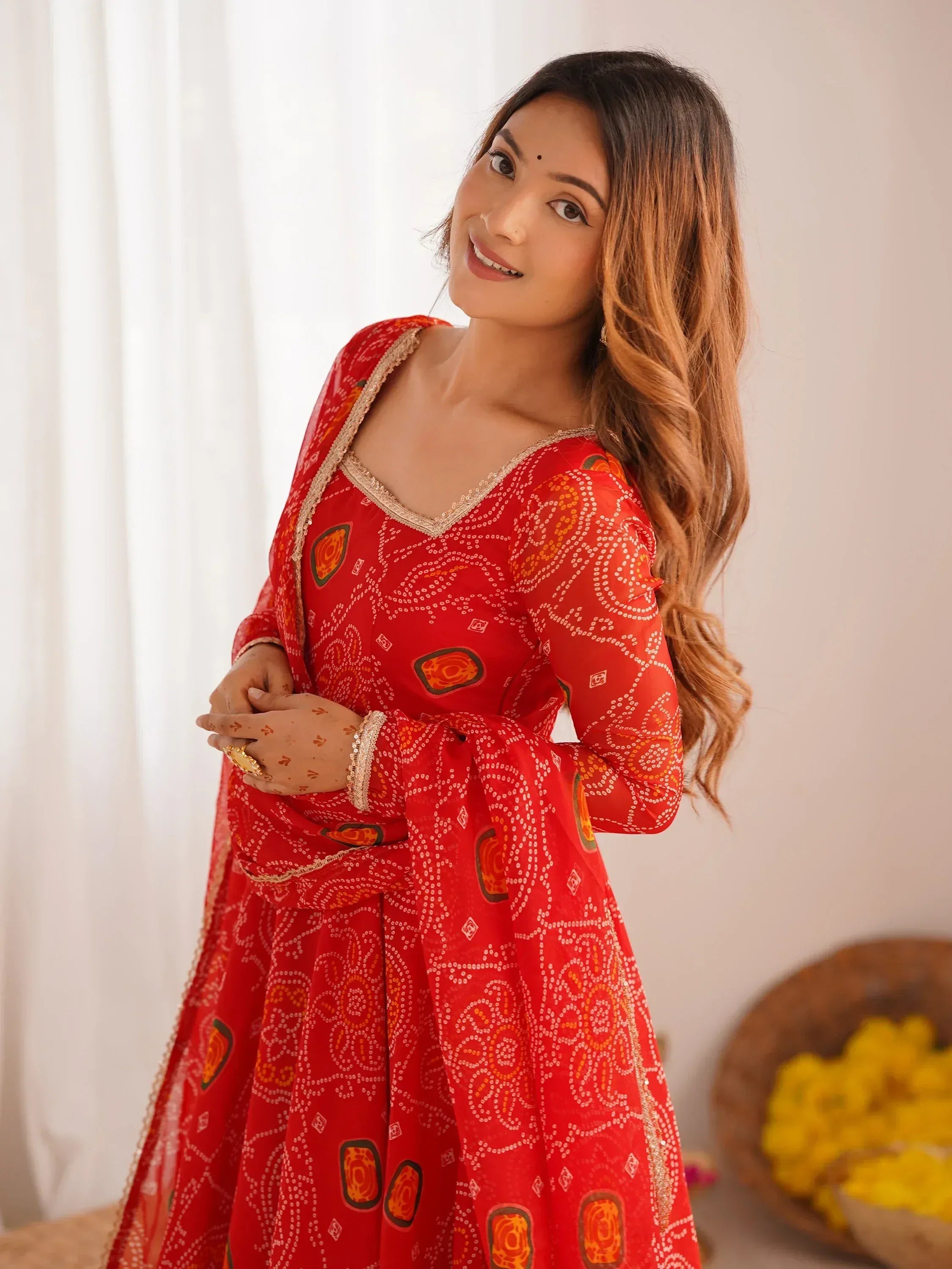 Woman in red printed ethnic gown with gold trim, perfect for Indian occasions and festivals