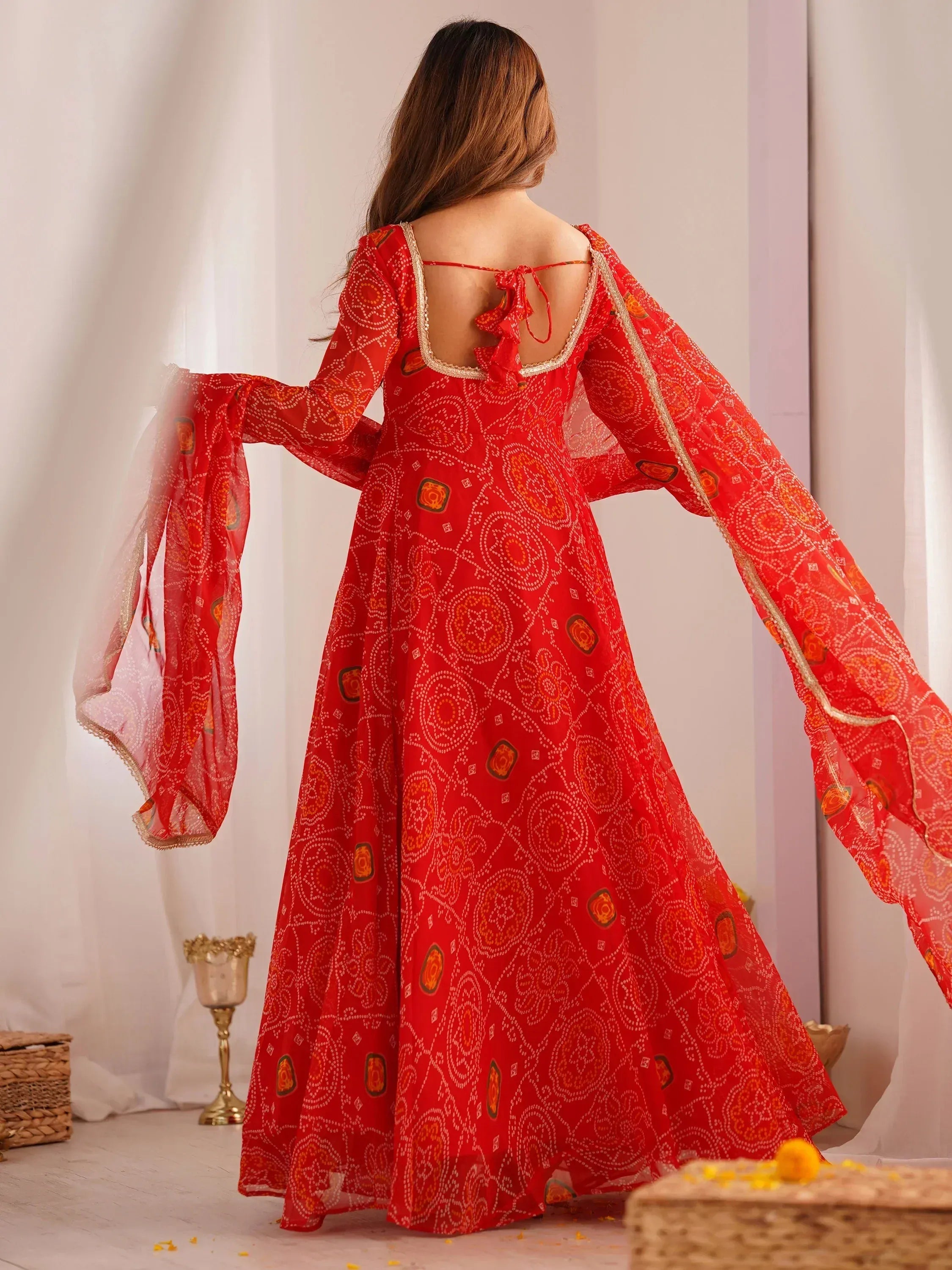 Red printed ethnic gown with flared sleeves and back tie detail, perfect for Indian occasions