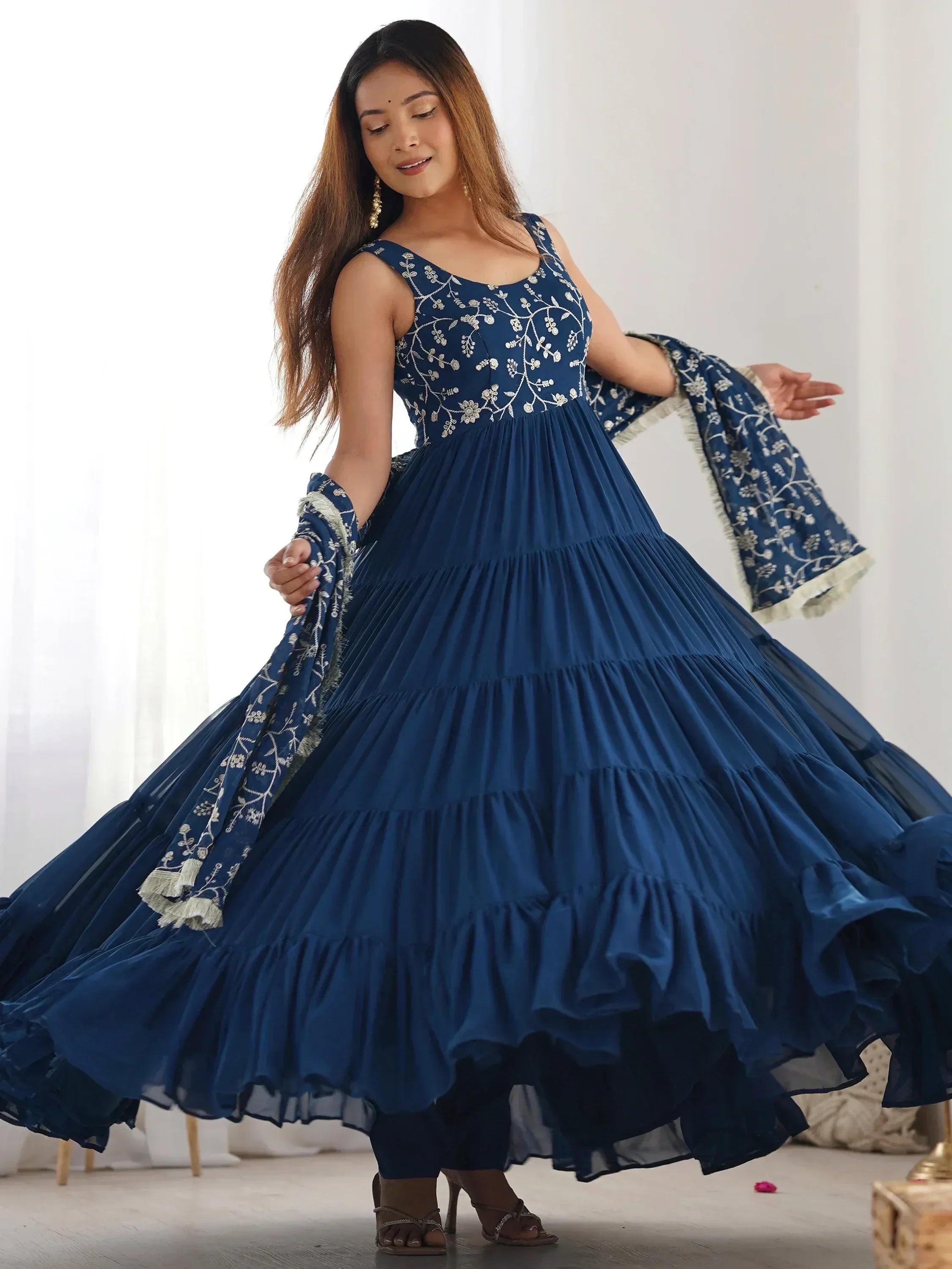 Woman twirling in a navy blue embroidered gown with dupatta, ethnic Indian dress fashion