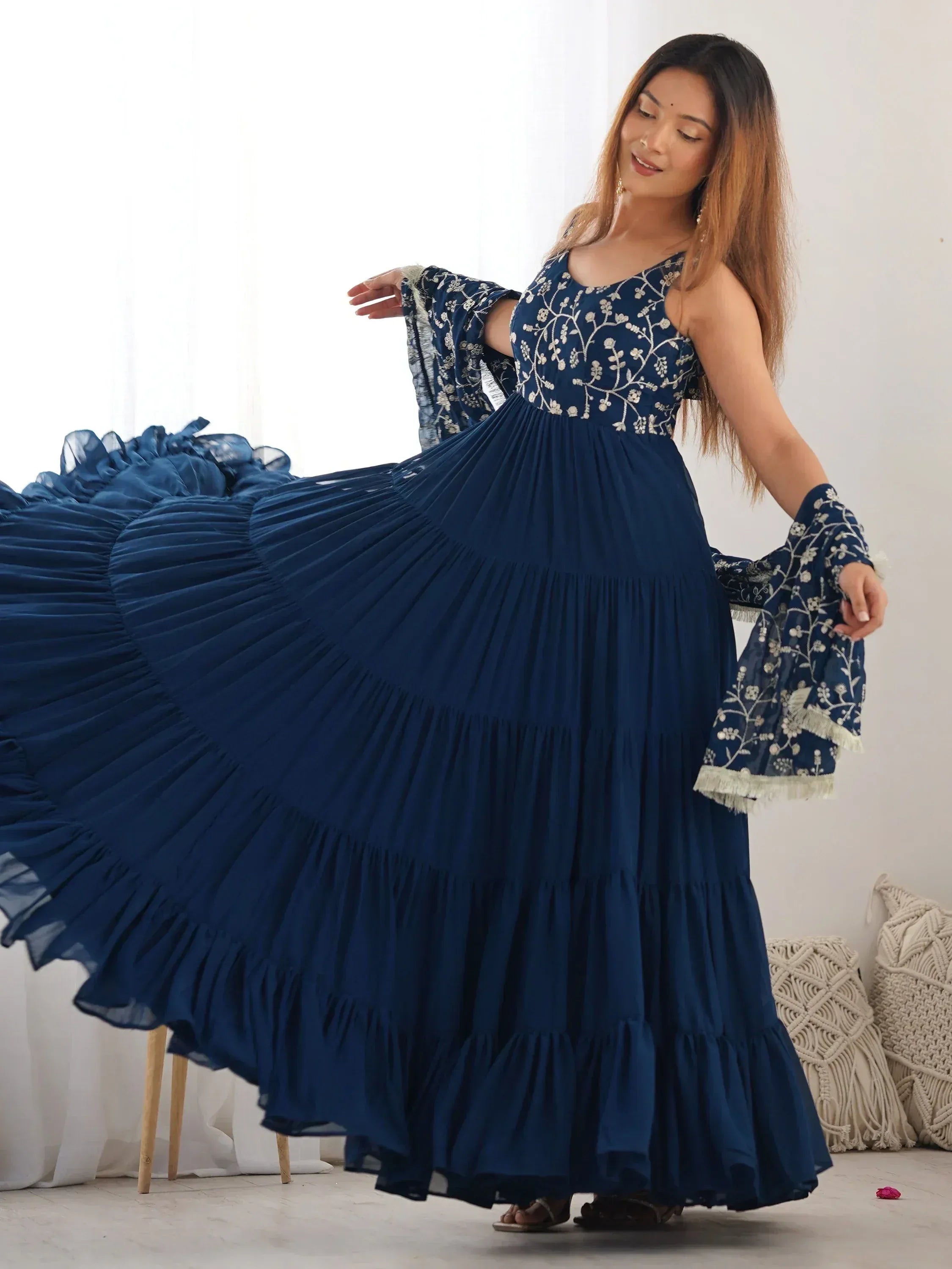 Woman wearing a navy blue embroidered ethnic gown with flared skirt and dupatta