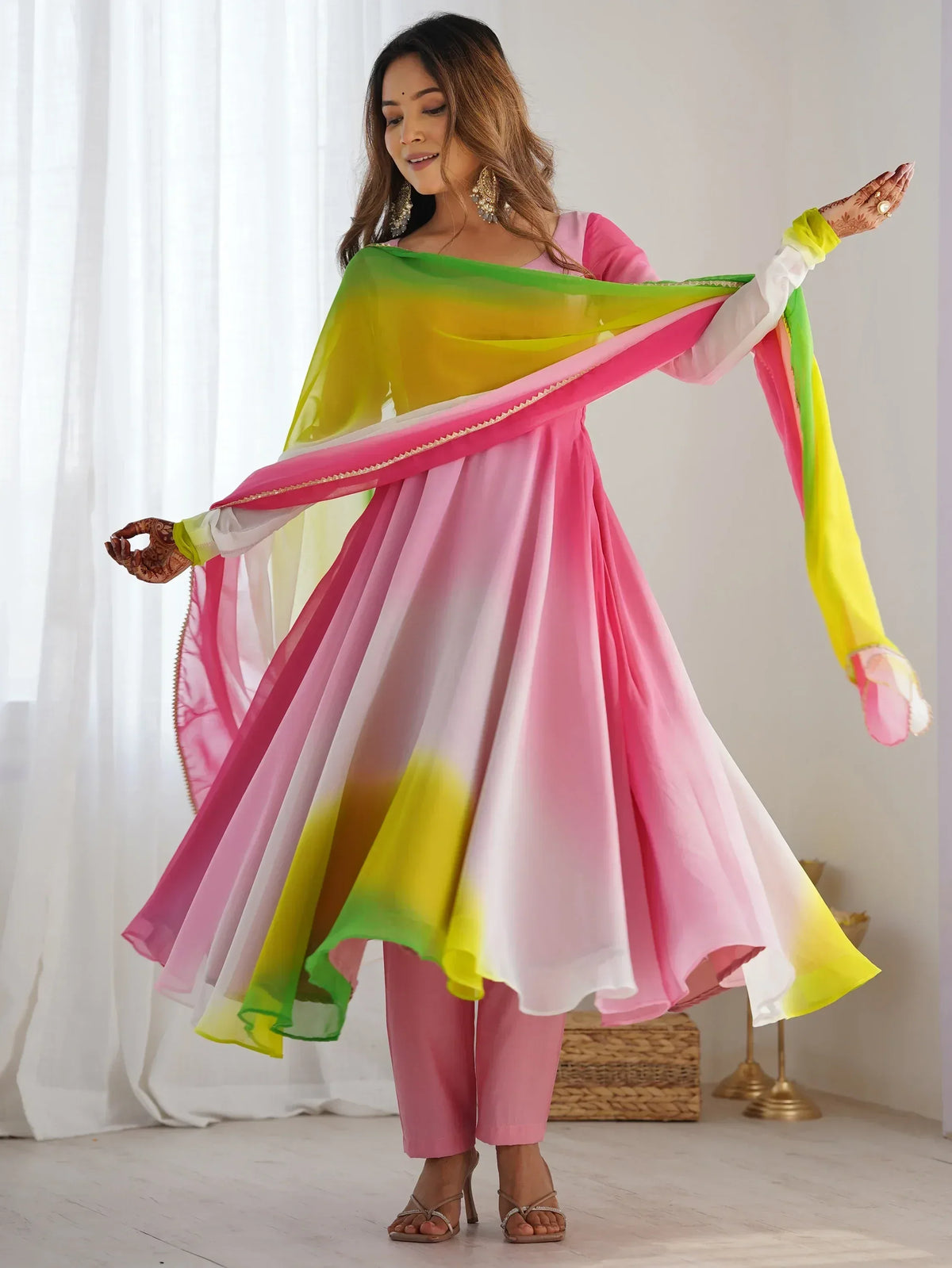 Woman in vibrant pink and yellow ombre salwar kameez with matching dupatta, perfect for Indian ethnic occasions.