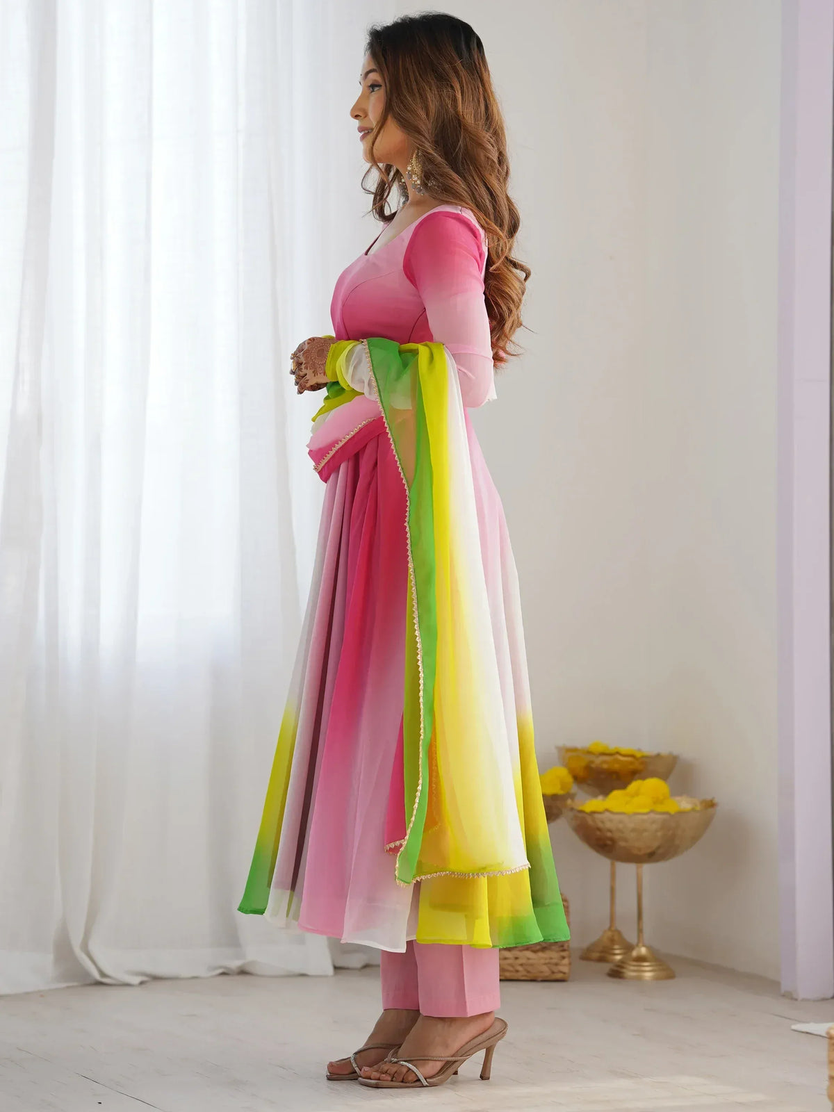 Woman in pink and green ombre Indian ethnic anarkali suit with dupatta, perfect for festive occasions.