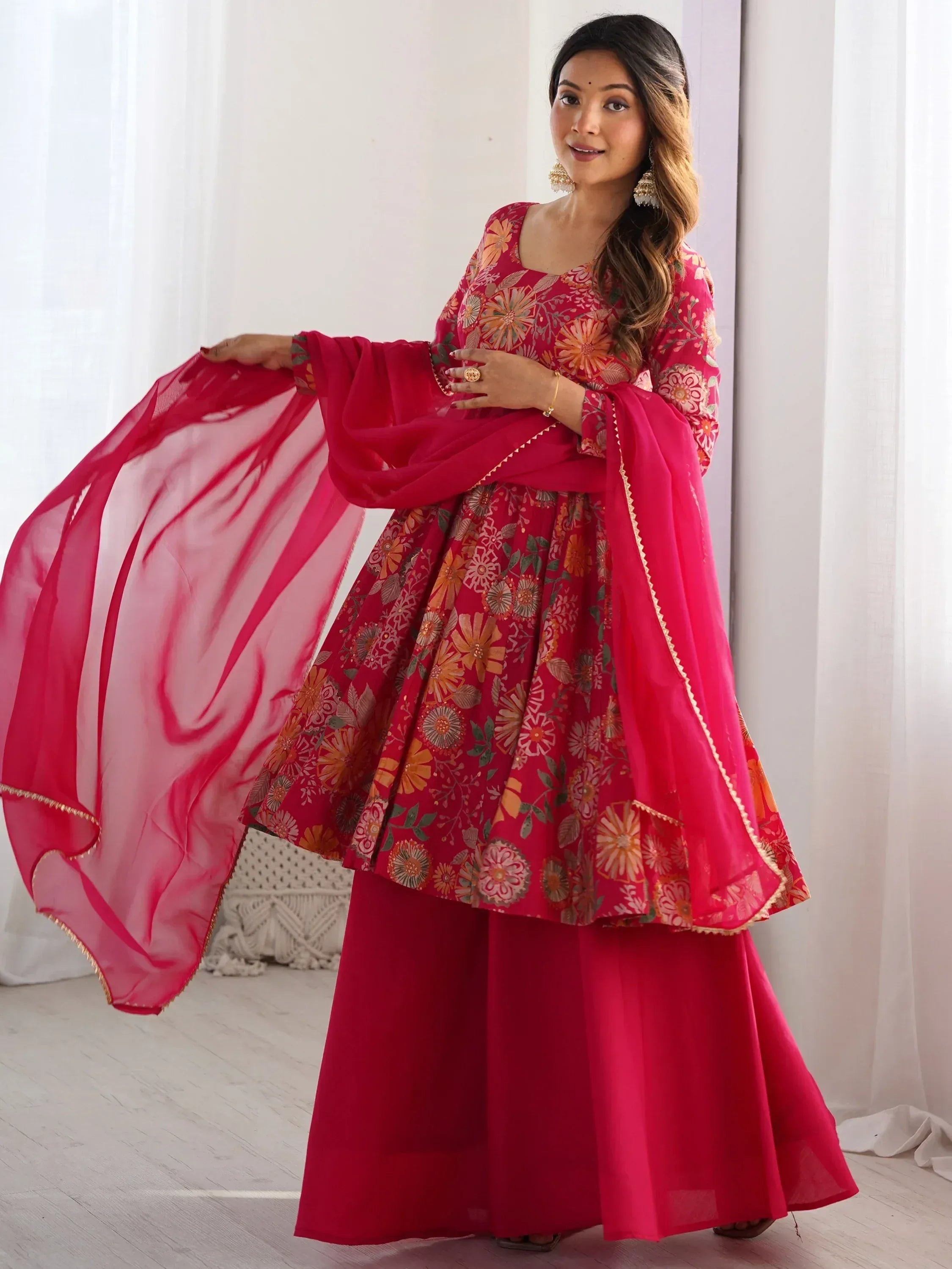 Vibrant pink floral ethnic gown with matching dupatta, perfect for festive occasions