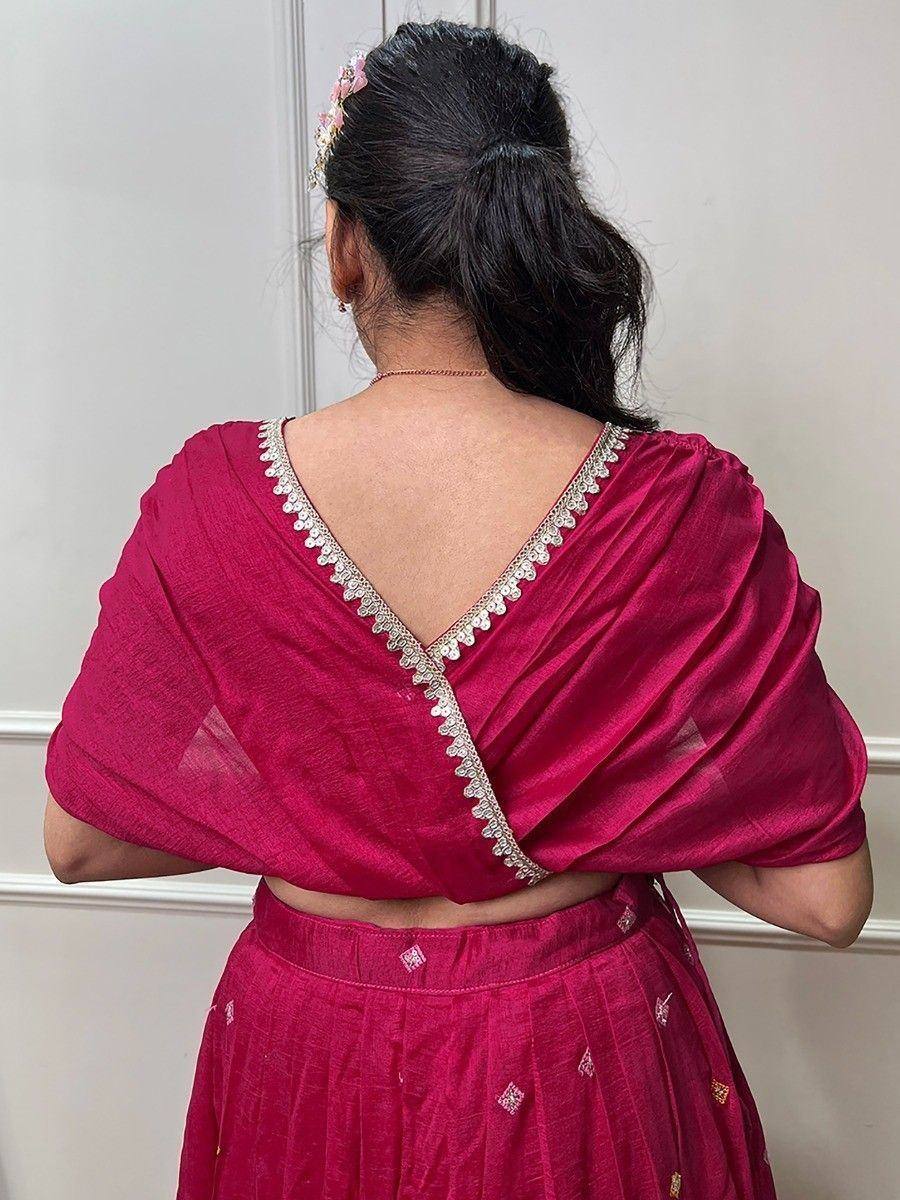 Back view of woman in pink ethnic lehenga choli with silver embellished V-back blouse