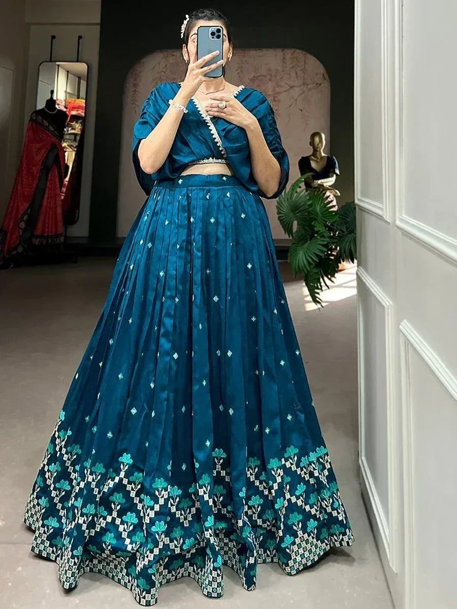 Teal blue designer lehenga choli with floral border, perfect for Indian ethnic wear occasions