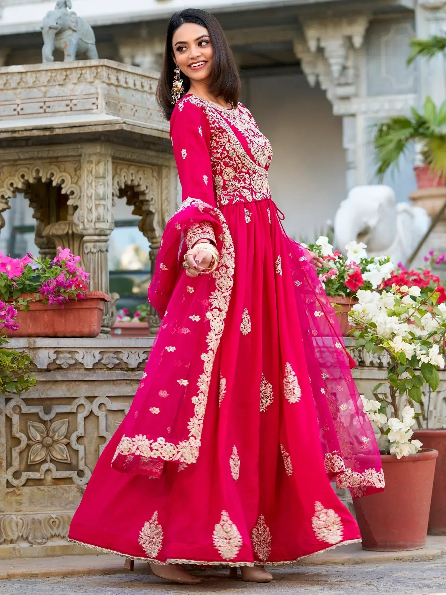 Elegant pink ethnic gown with gold embroidery, perfect for Indian celebrations and festive occasions.