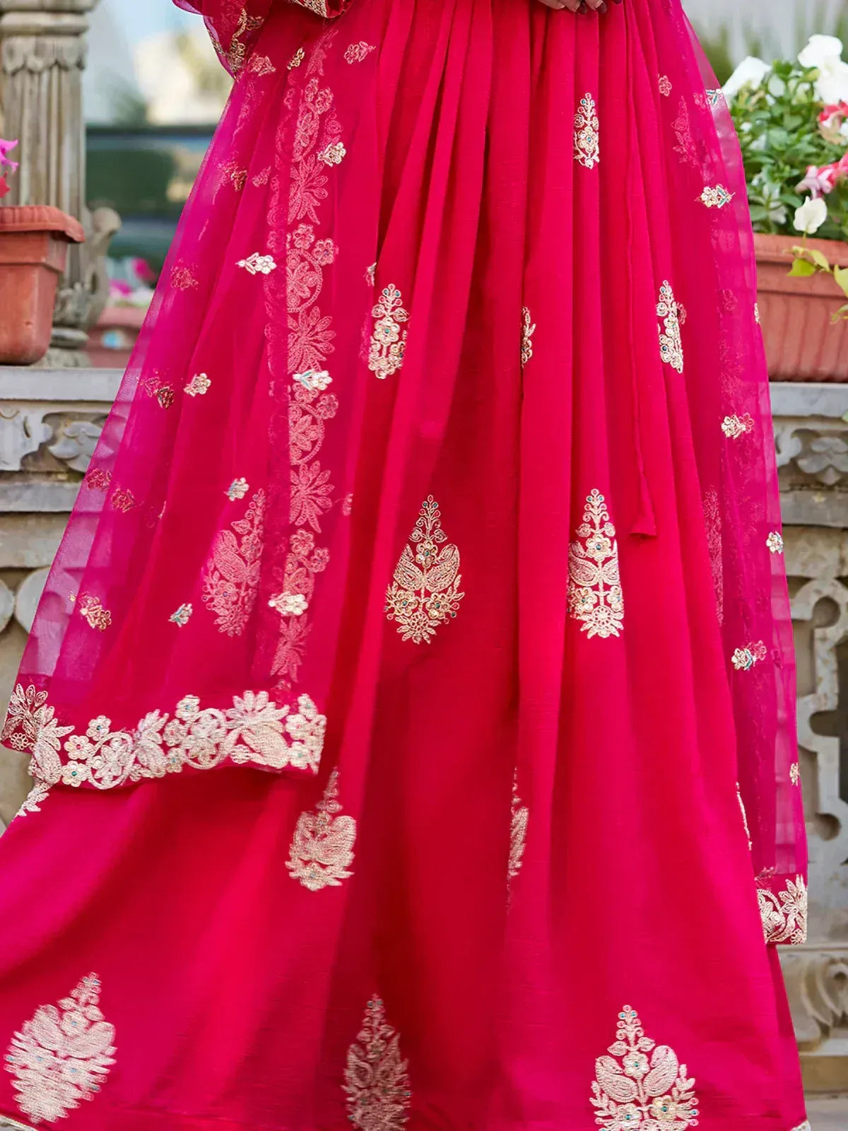 Vibrant pink ethnic lehenga with intricate gold embroidery and floral motifs, perfect for festive occasions.
