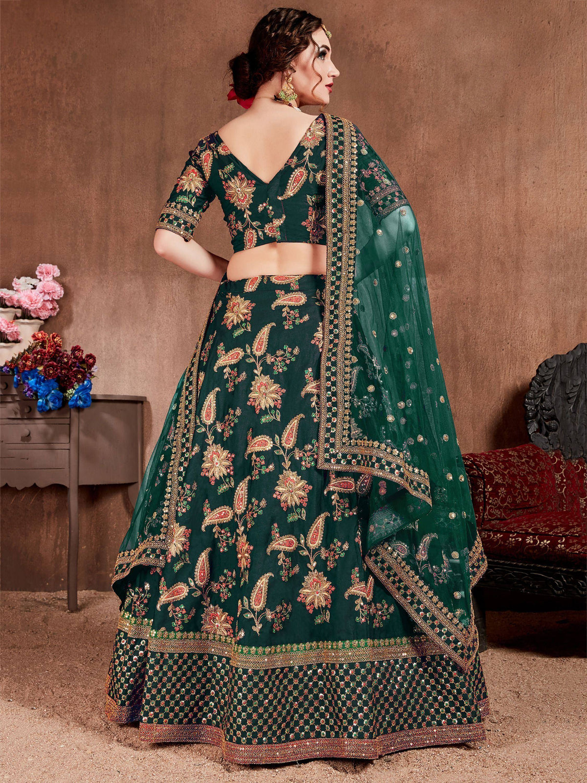 Emerald green designer lehenga choli with floral embroidery and gold detailing, perfect for Indian weddings.