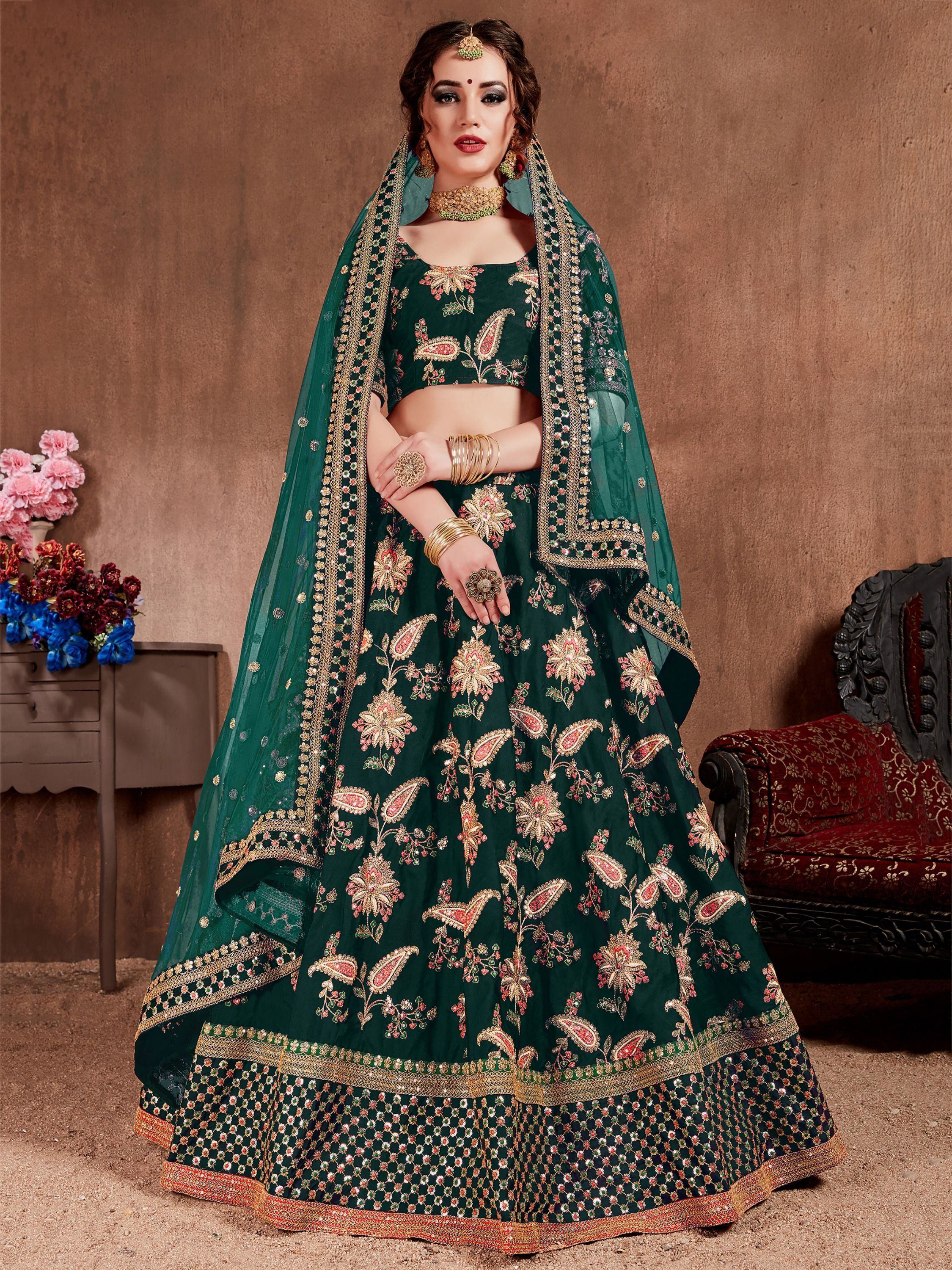 Emerald green designer lehenga choli with floral embroidery and gold detailing, perfect for Indian weddings.