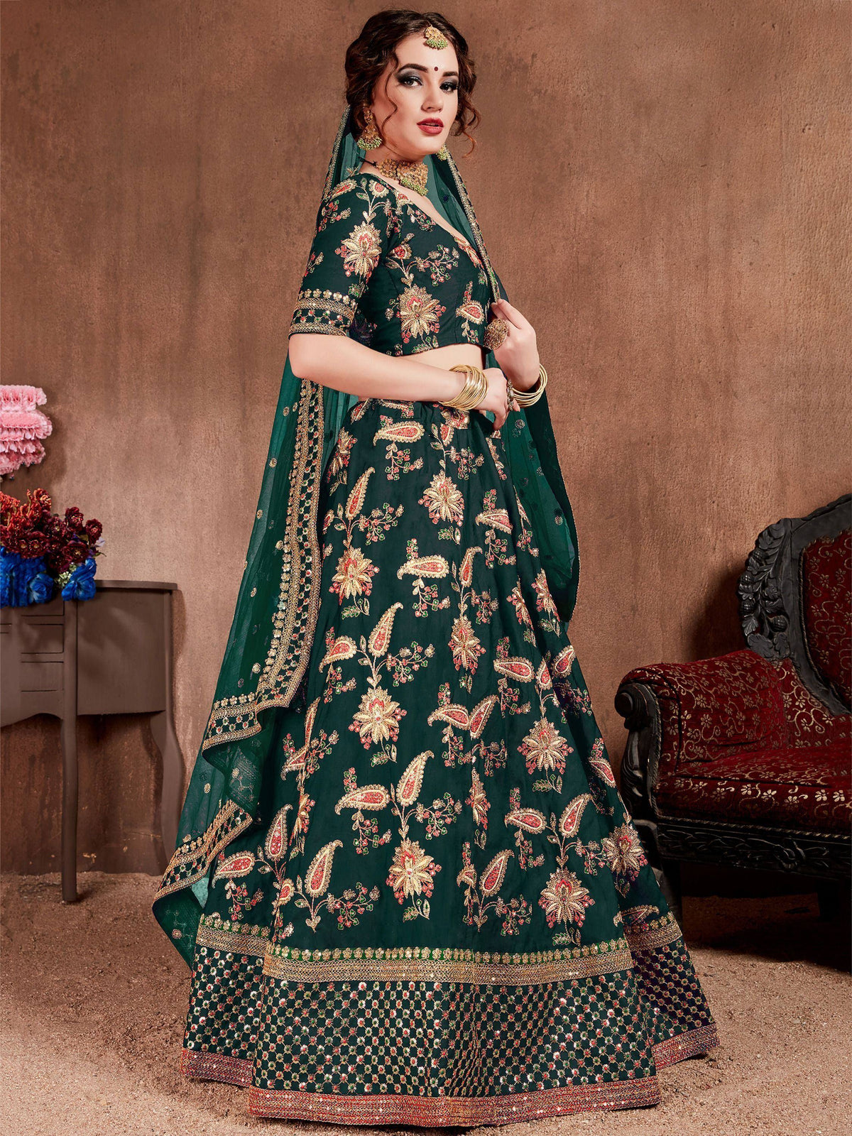 Emerald green designer lehenga choli with floral embroidery and gold detailing, perfect for Indian weddings.