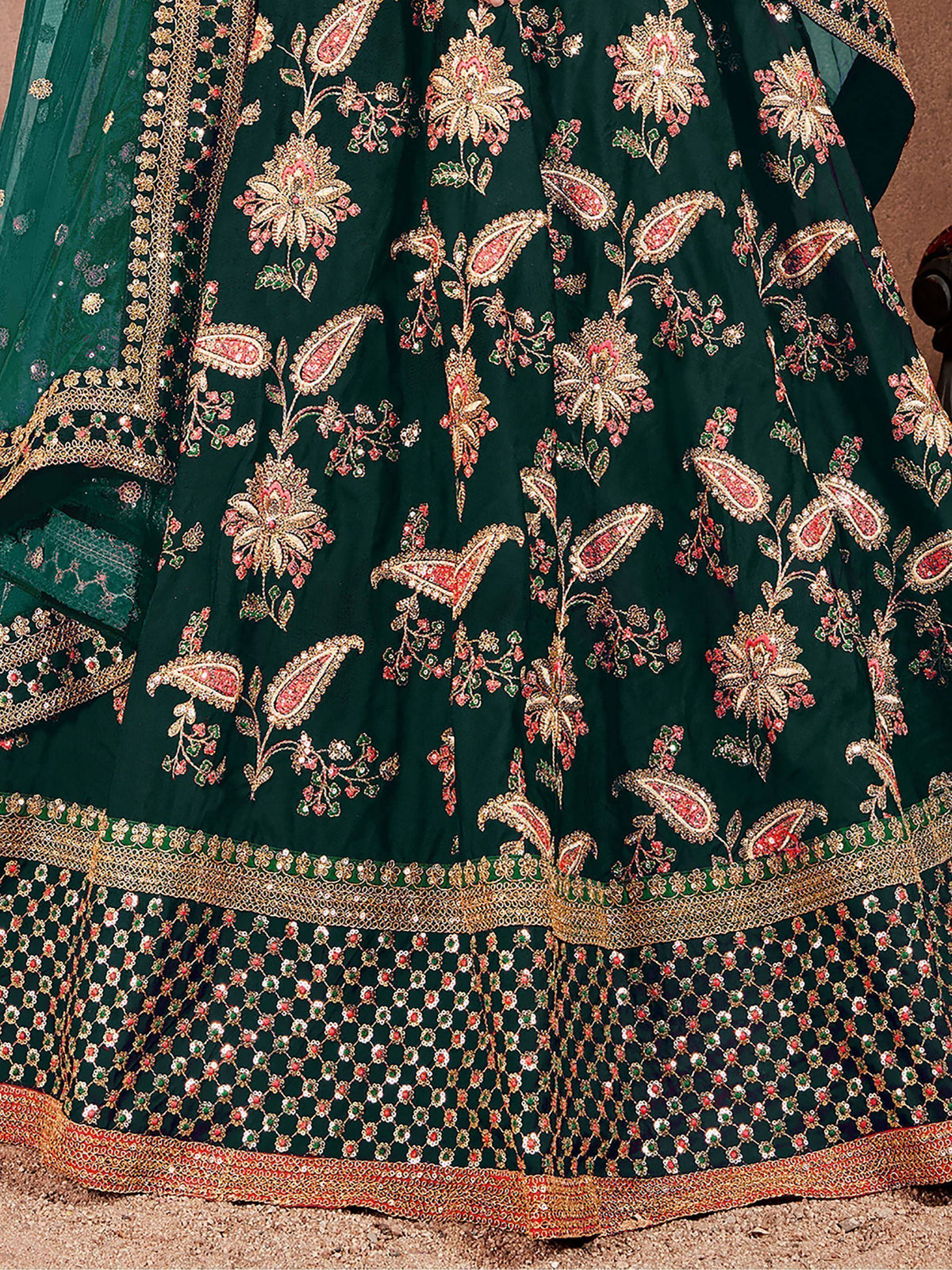 Emerald green lehenga with intricate gold, pink, and green floral embroidery and heavy border detailing