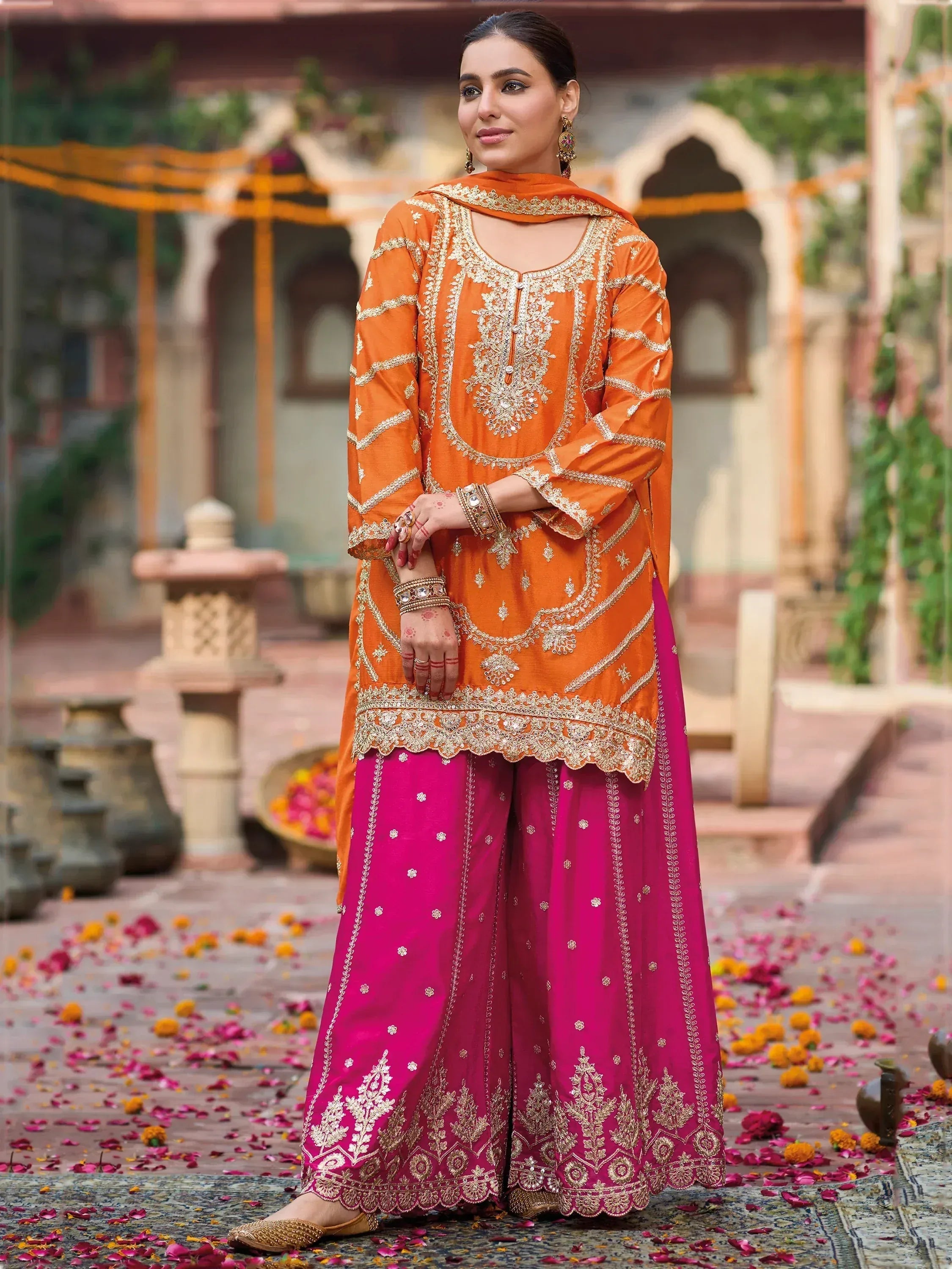 Orange and pink embroidered salwar kameez with gold detailing, perfect for festive occasions and ethnic wear.
