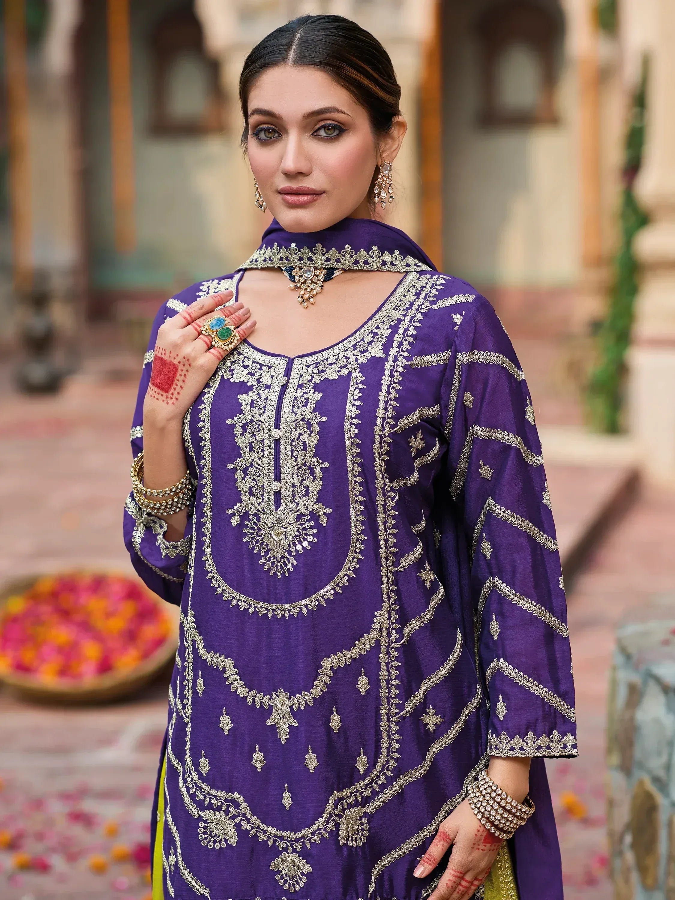 Purple embroidered ethnic kurti with gold detailing and traditional jewelry