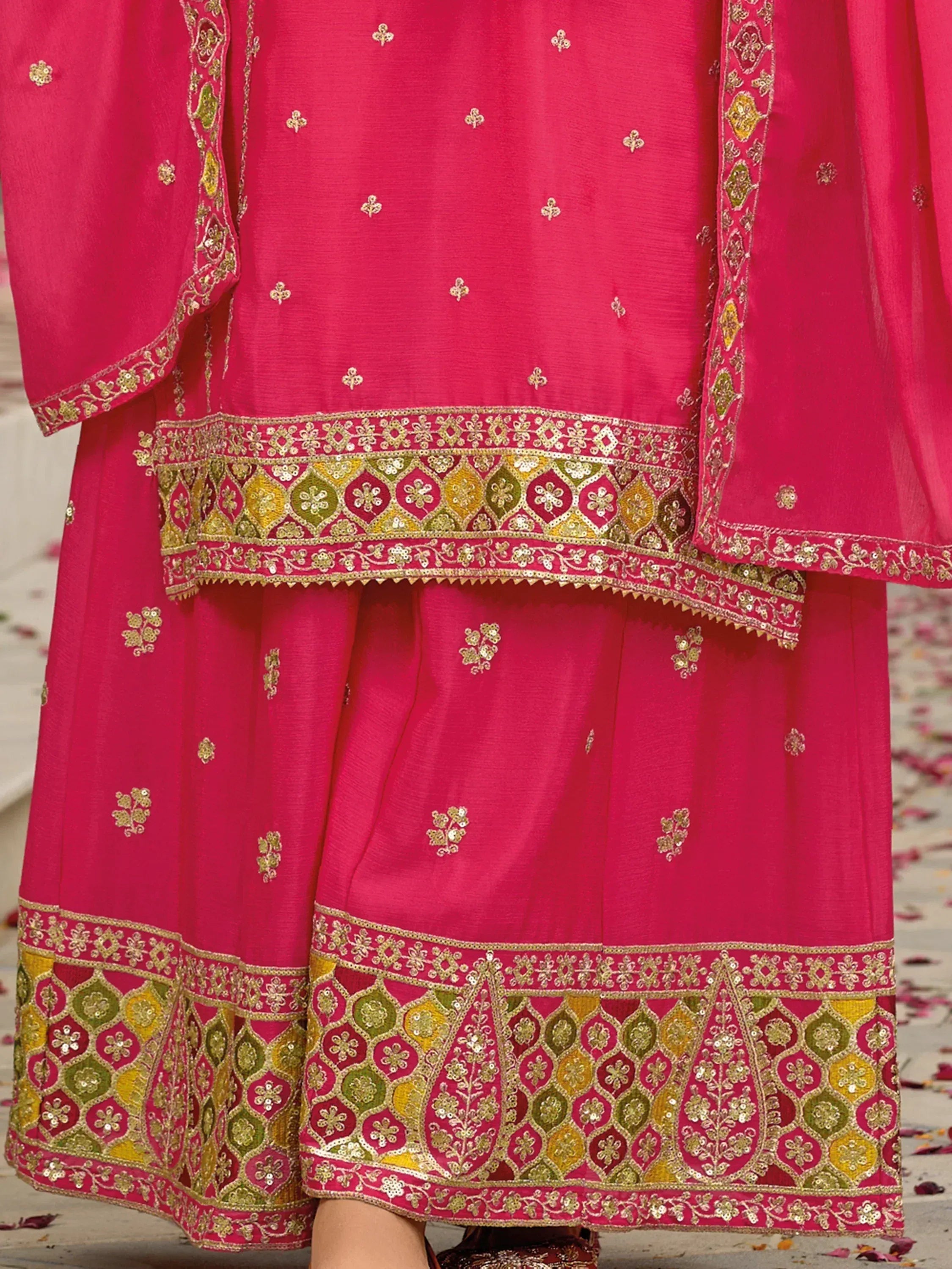 Pink Indian ethnic salwar kameez with gold and green embroidery, floral motifs, and detailed borders